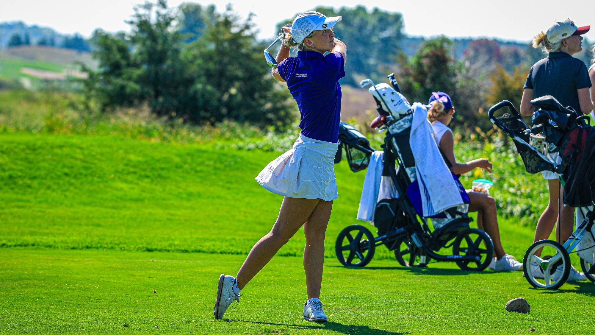 Women's Golfer watching shot after hitting the ball