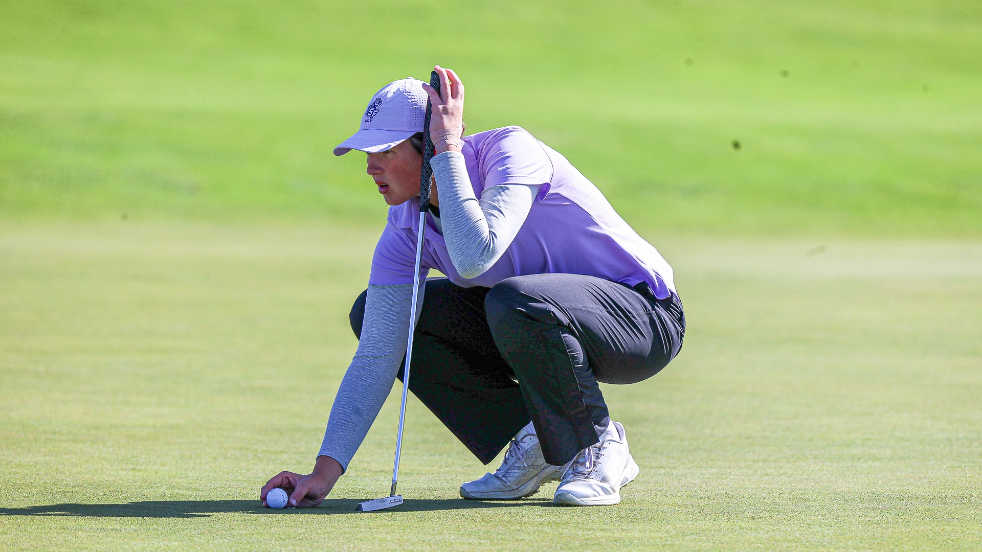 USF Golfer Gwen Latunski lines her ball up for a putt at the USF Invite