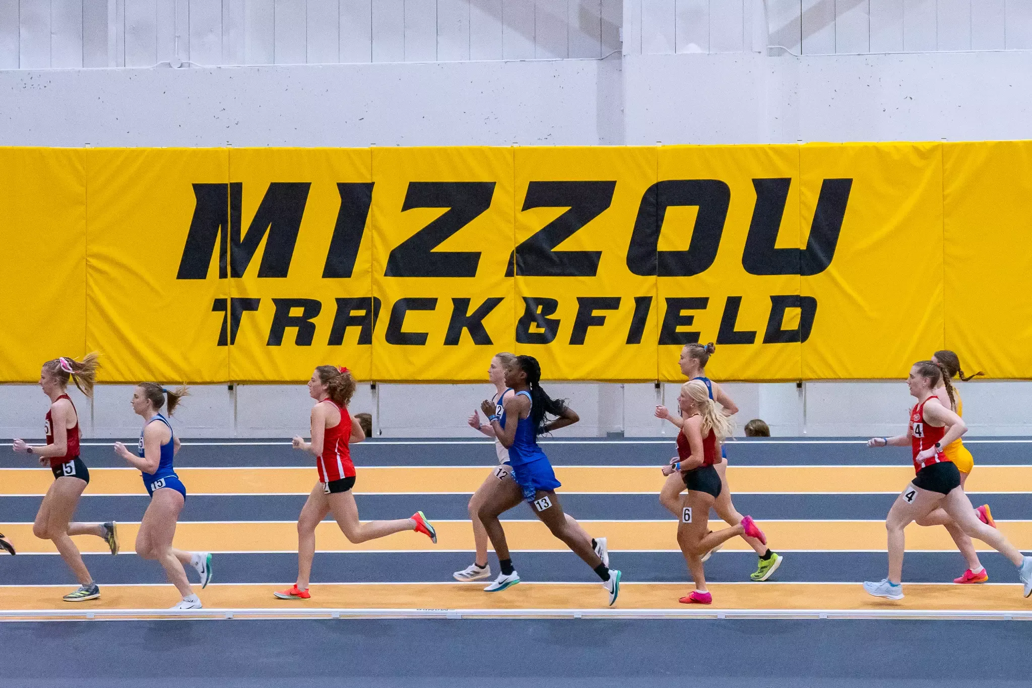 running in front of Missou logo