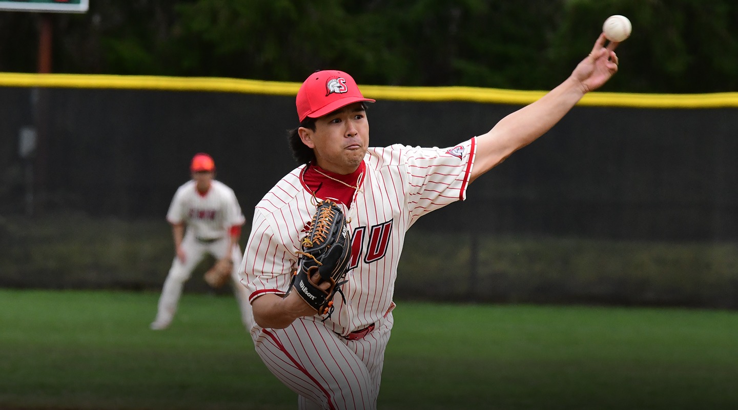 Tyler Young in the middle of pitching a ball