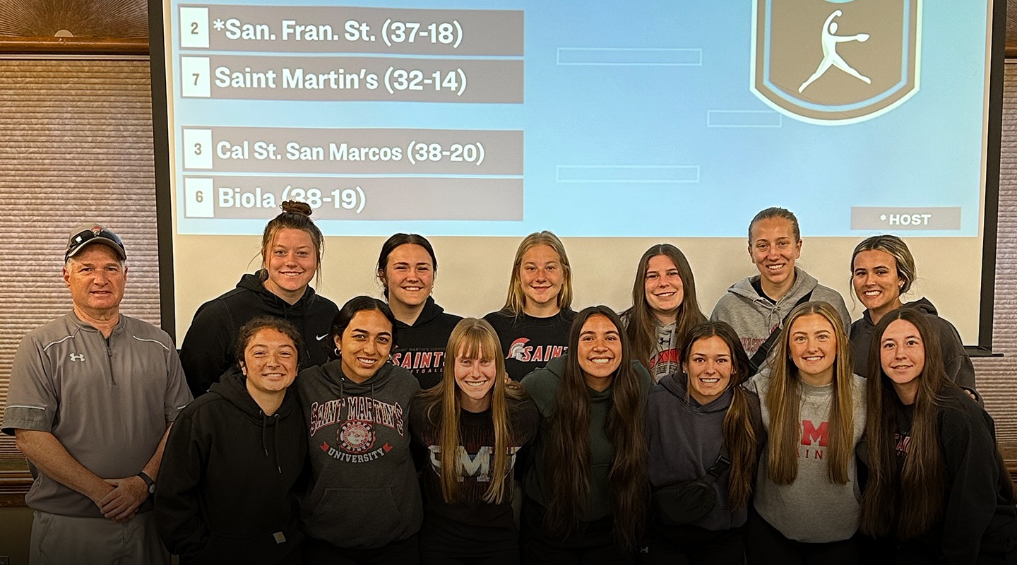 The 2025 SMU Softball team posed in front of the West Regional bracket