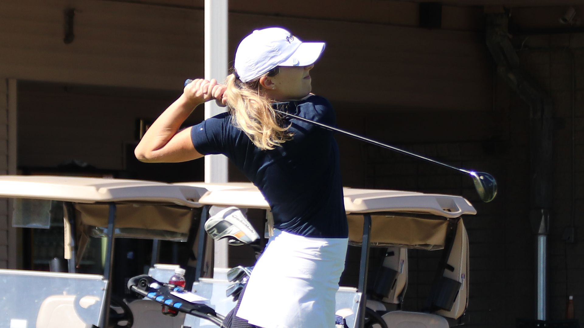Anna Casagrande hitting her tee shot with golf carts in the background