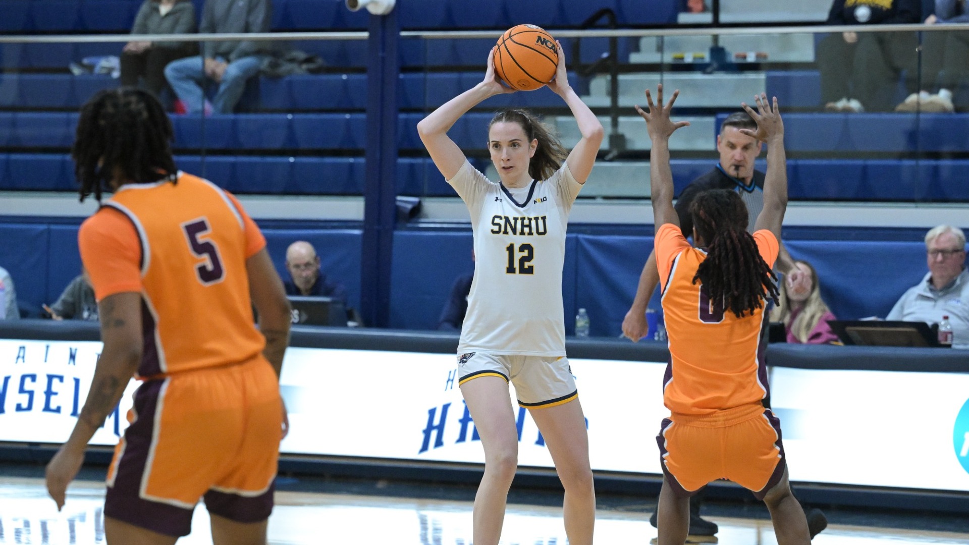 Women's basketball player Ava Winterburn is shown holding the ball high above her head in a recent game