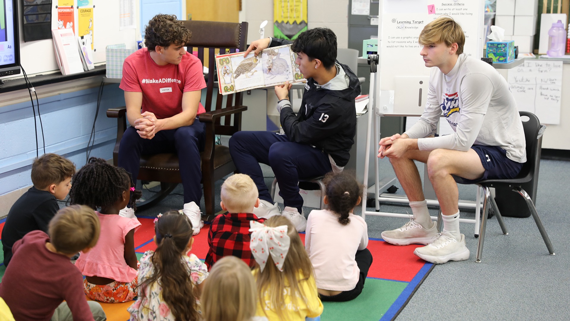 Members of the SNHU men's soccer team reading to students during its community engagement day at the NCAA Championship