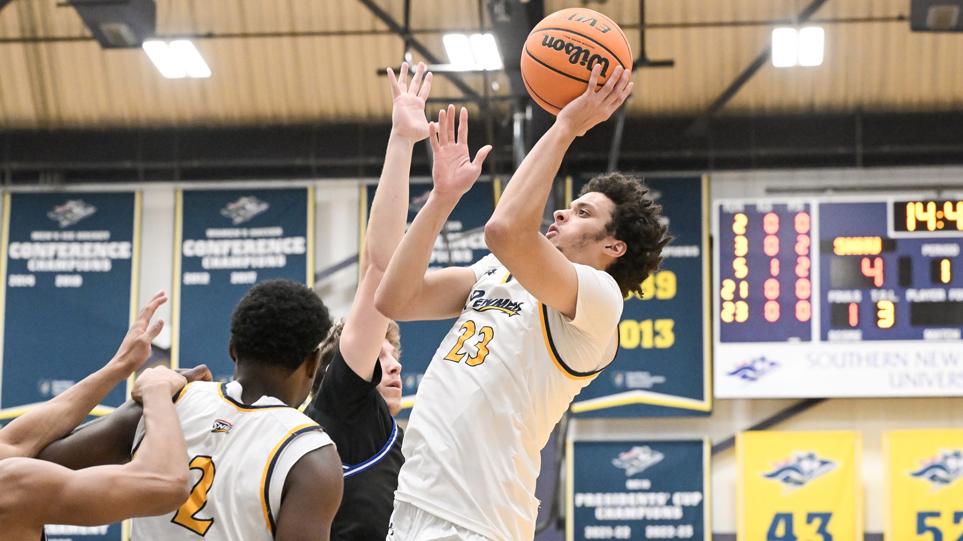 Jojo Wallace driving for a layup against two defenders