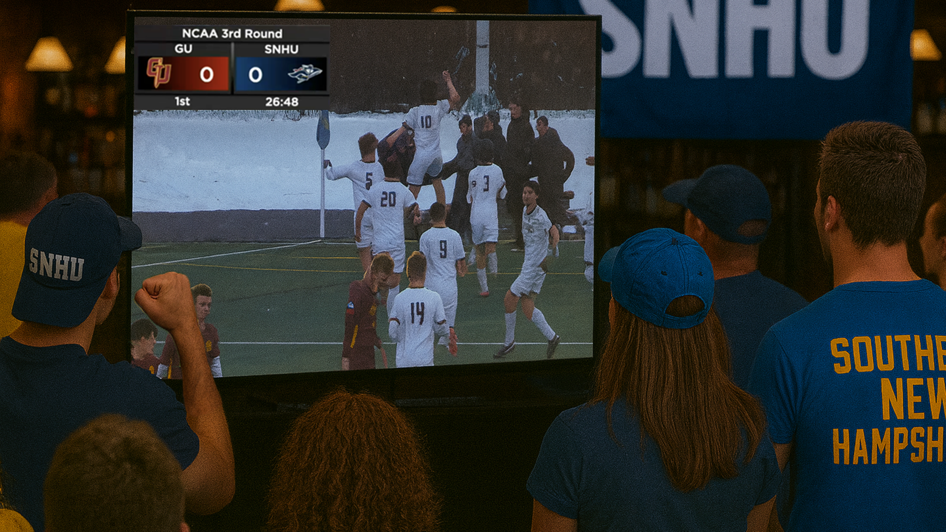 fans watching the SNHU men's soccer team on a TV in a pub