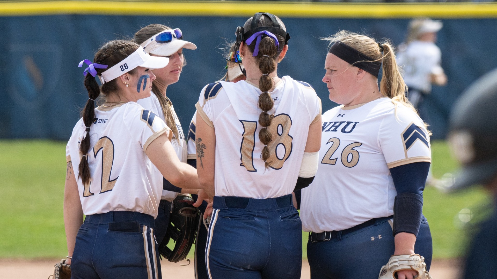Softball Team Gathers Around pitcher Julianna Colbert on the Mound