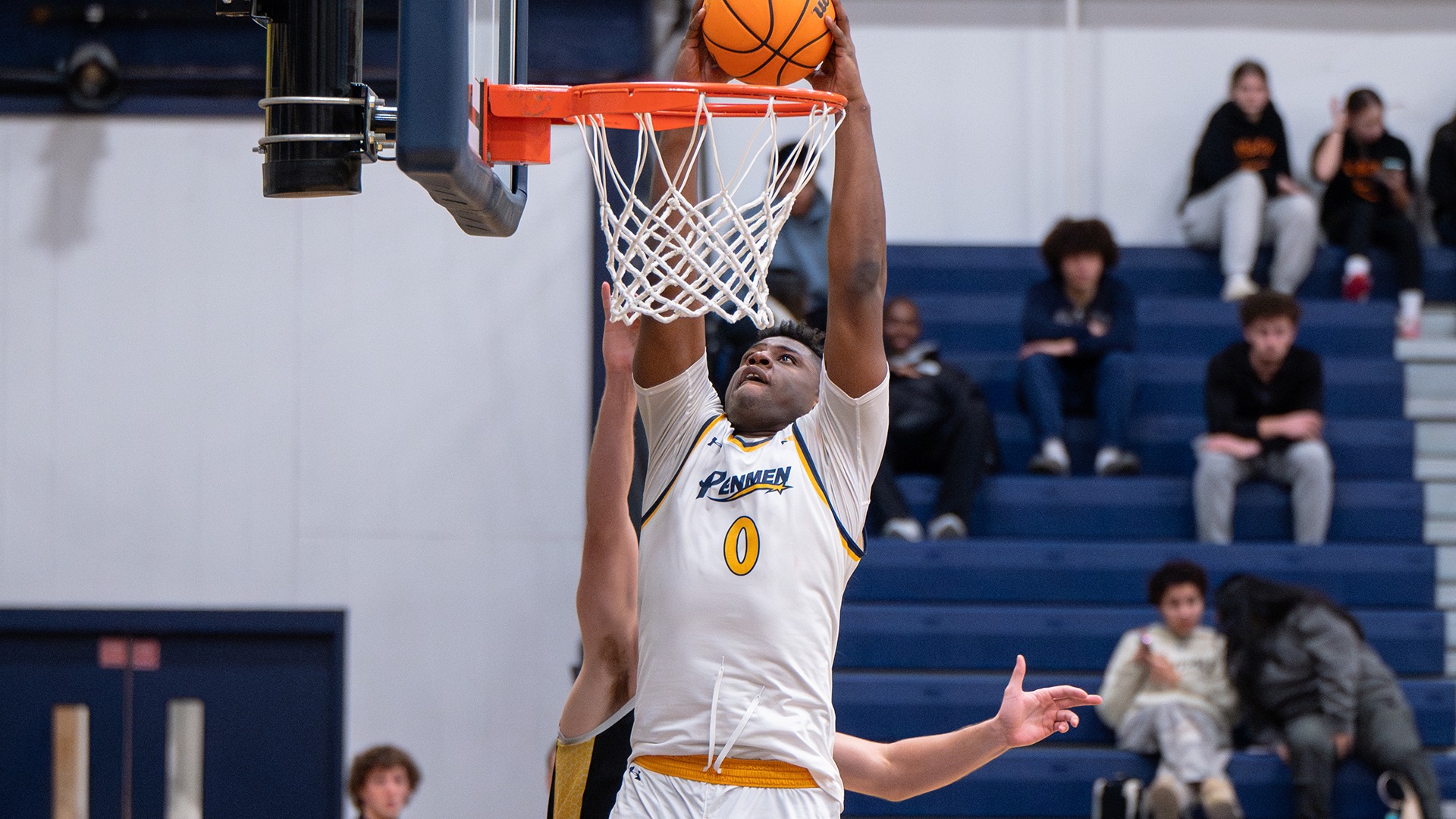 Nwachukwu dunking the basketball in front of a defender
