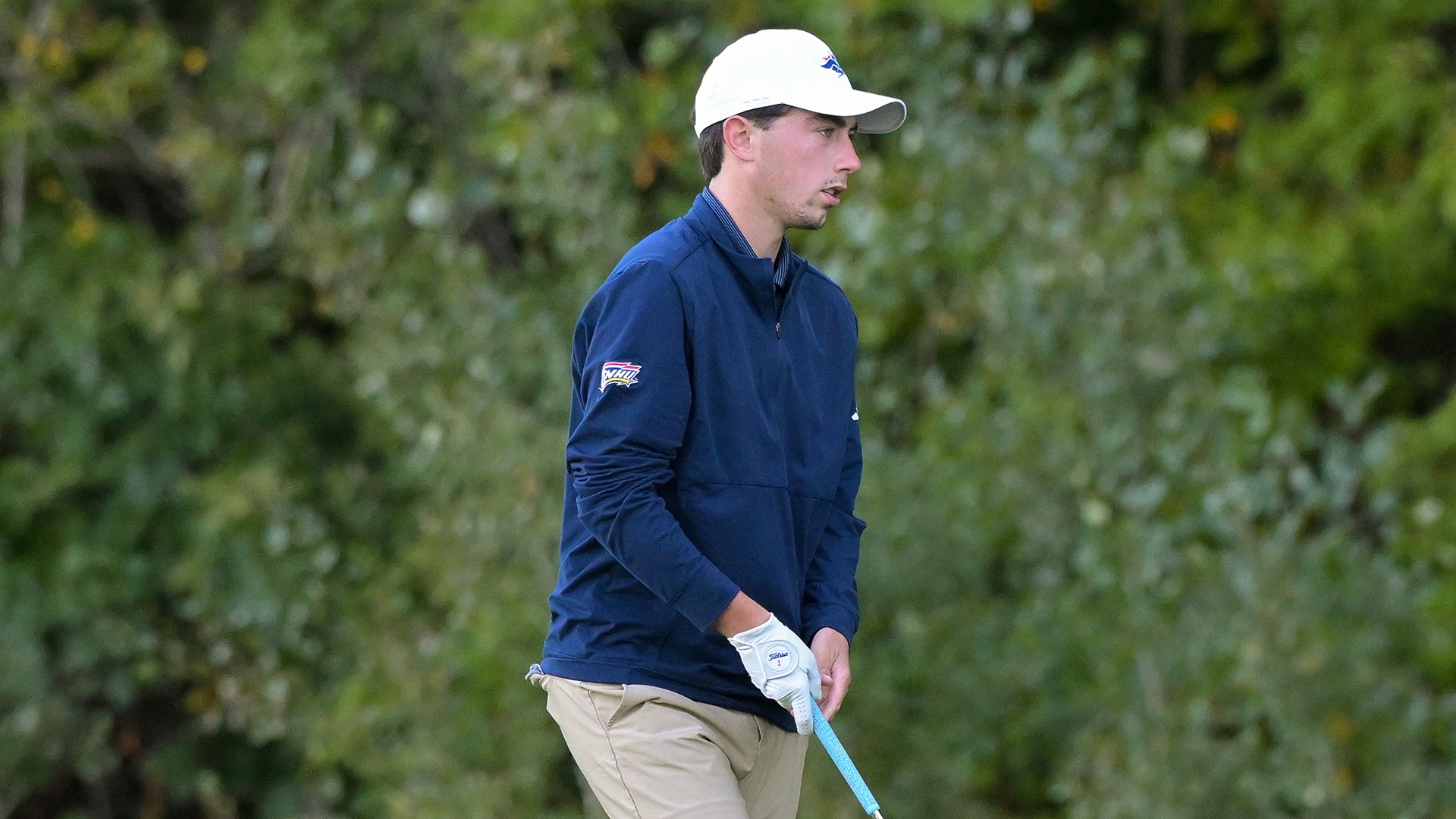 Andrew Surprenant walking up to his ball with an iron in his hand