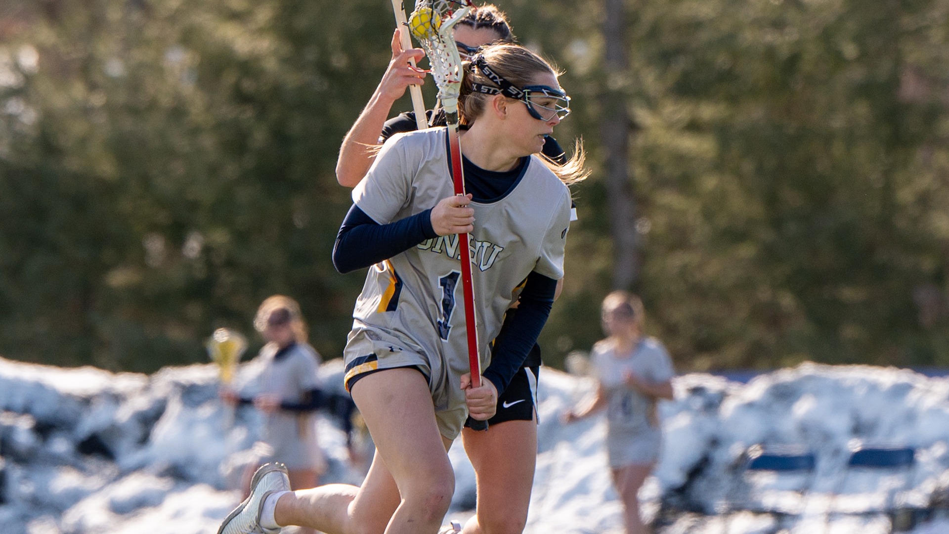 Piper Knowlton driving on a defender with the ball in her stick