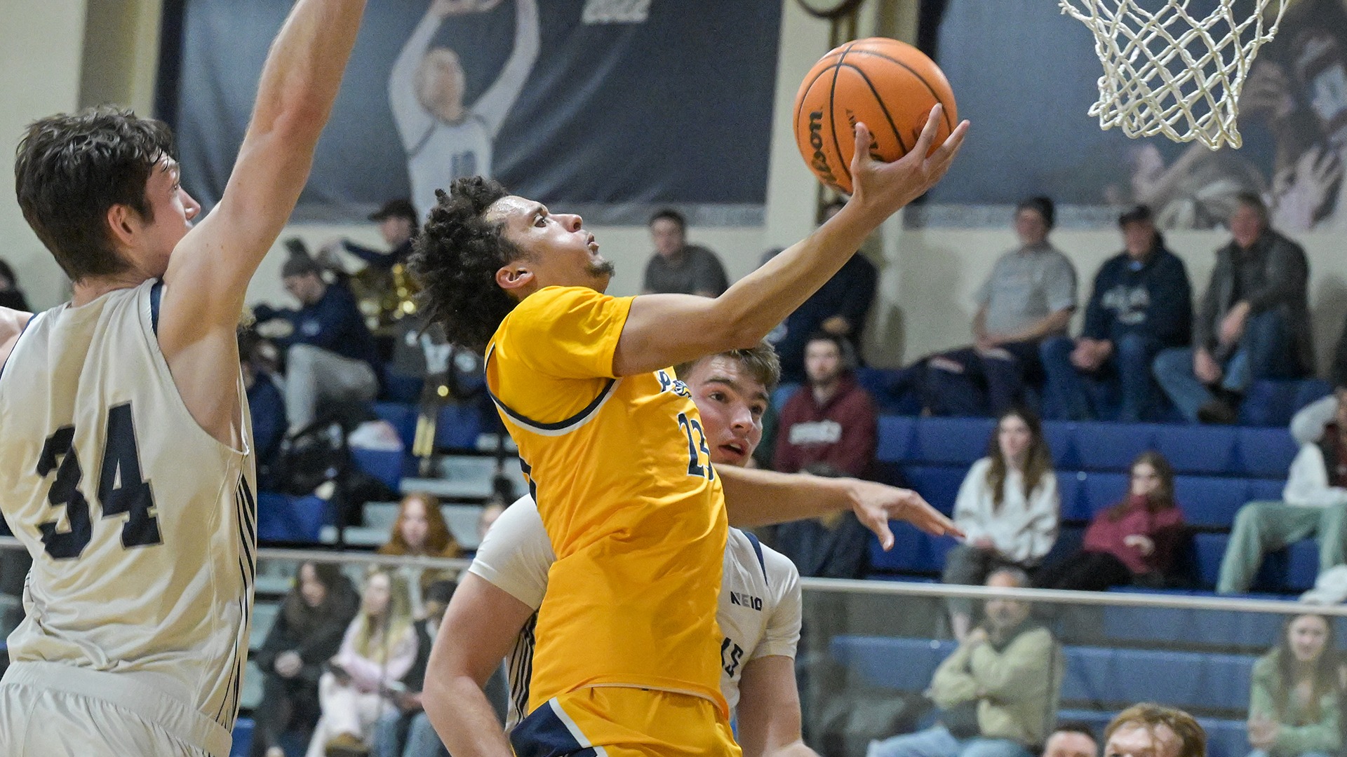 Jojo Wallace driving for a layup against two defenders