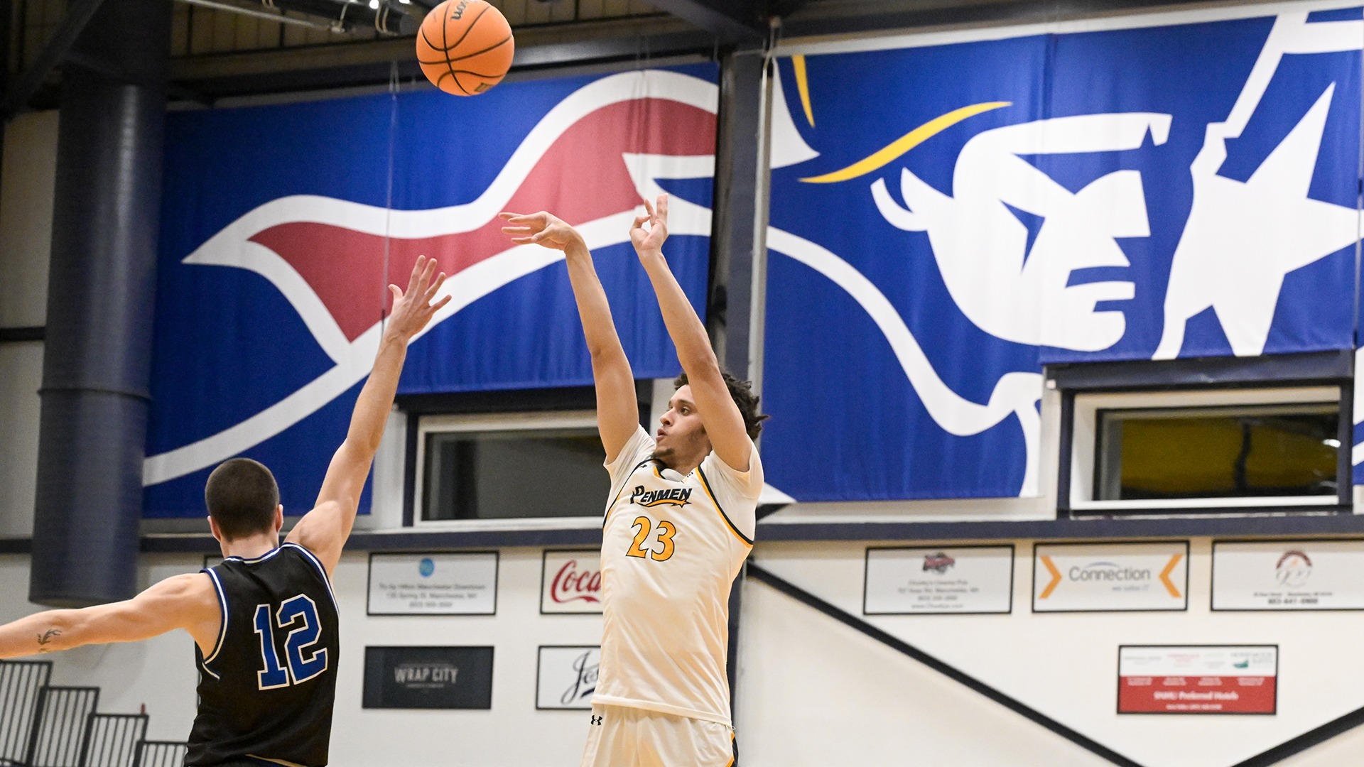 Jojo Wallace shooting a 3-pointer over the outstretched hand of a defender