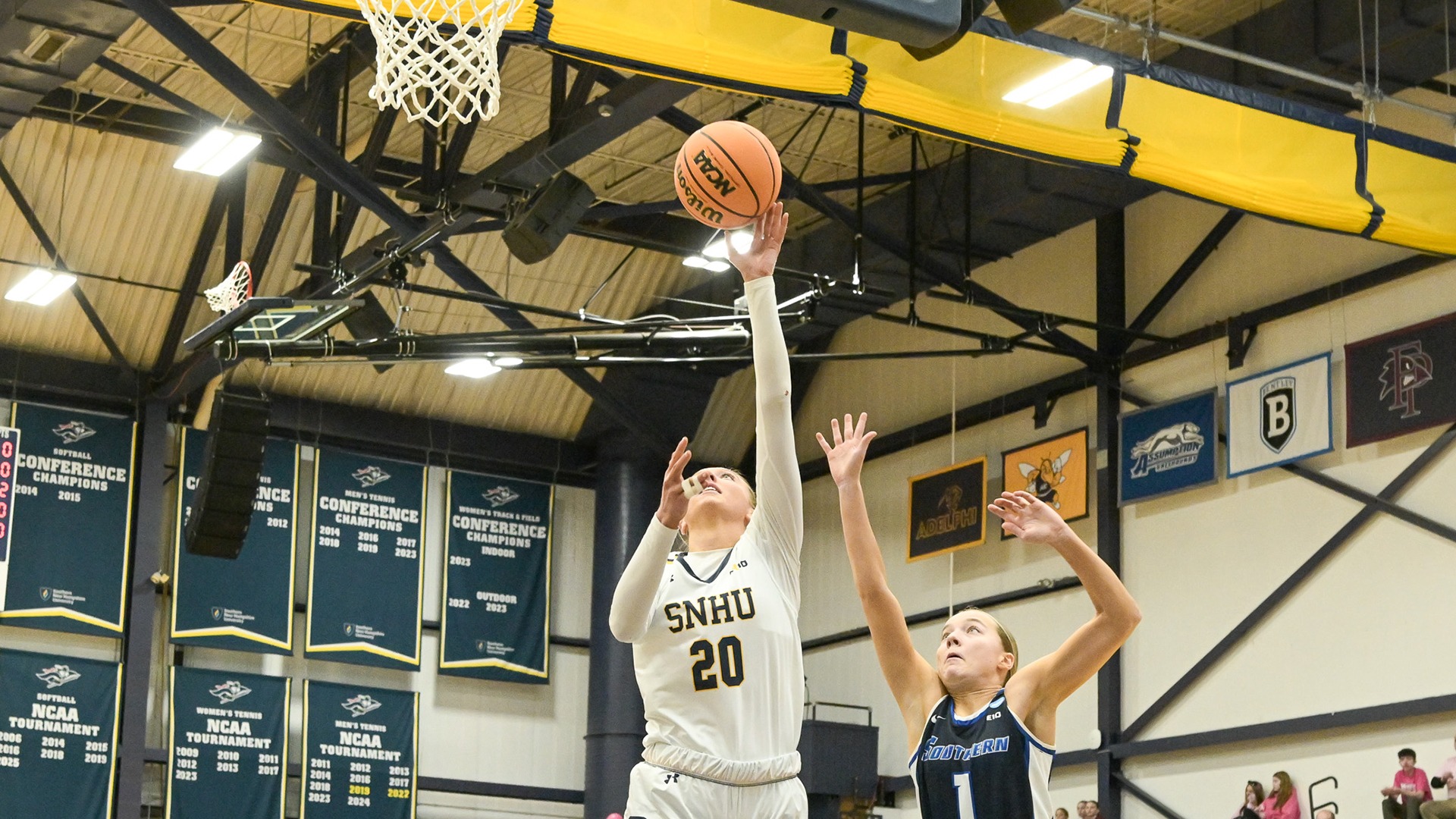 Sydnie DeVries going for a layup with a defender attempting to block her from behind