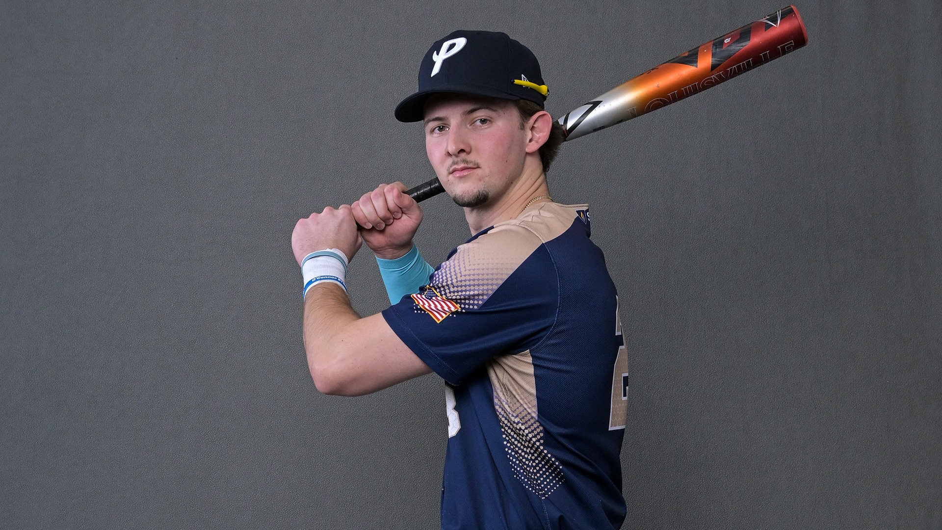 Brody Keneston posing for a marketing photo with his bat