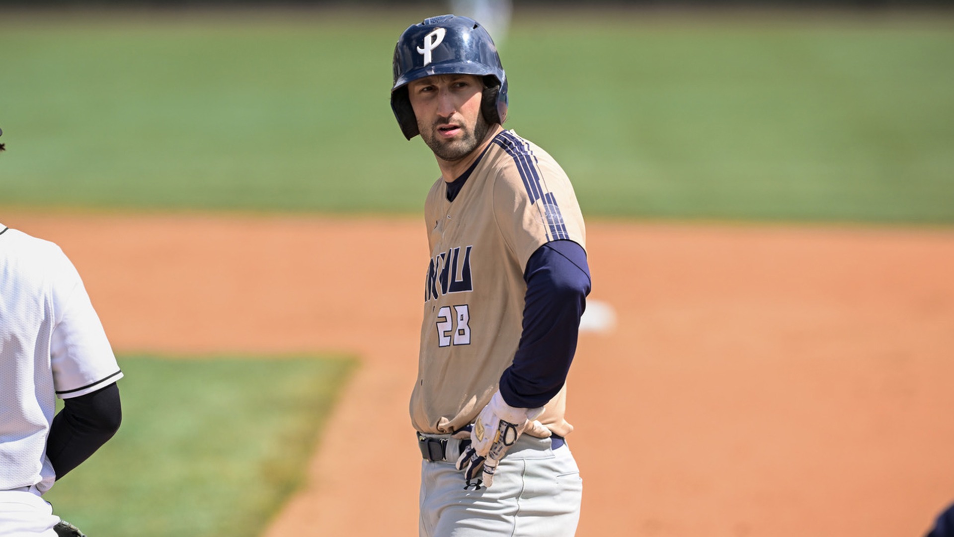 Jake Pisano standing on first base with his hands on his hips