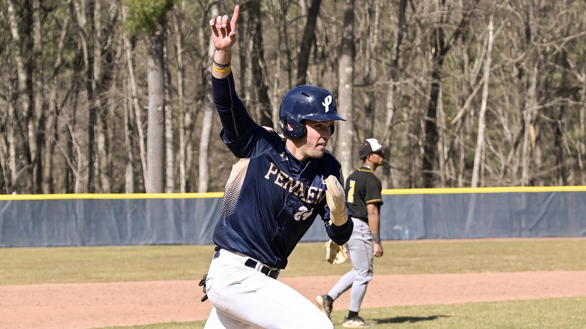 Shane McNamara with his index finger in the air as he runs home to score the winning run