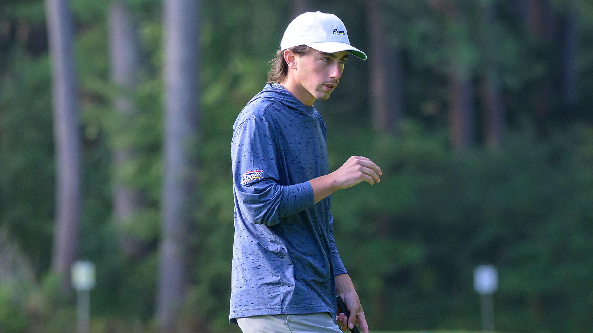 Andrew Surprenant walking on the green with his putter