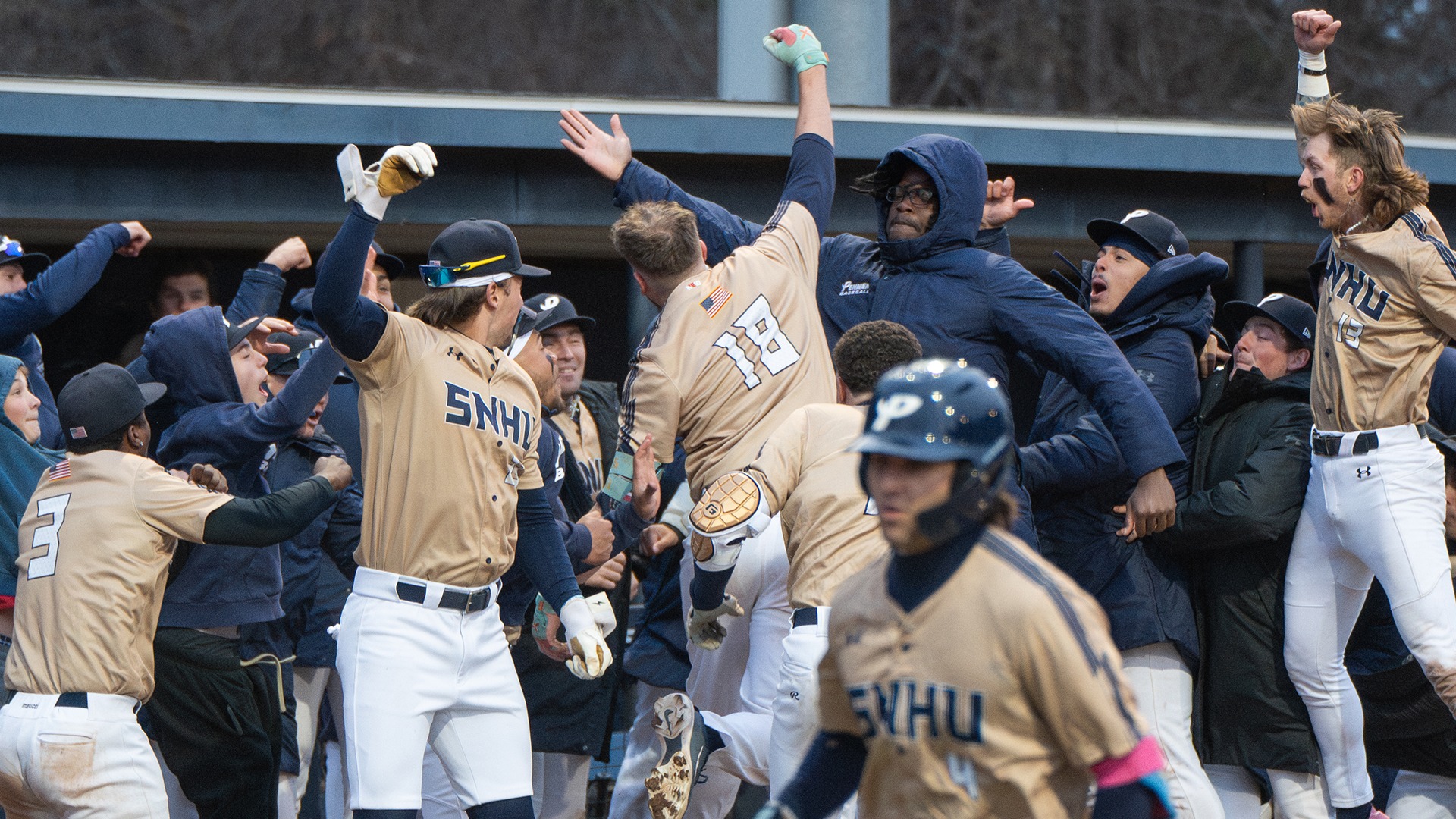 Kyle Lavigne celebrates his home run with teammates at the SNHU dugout