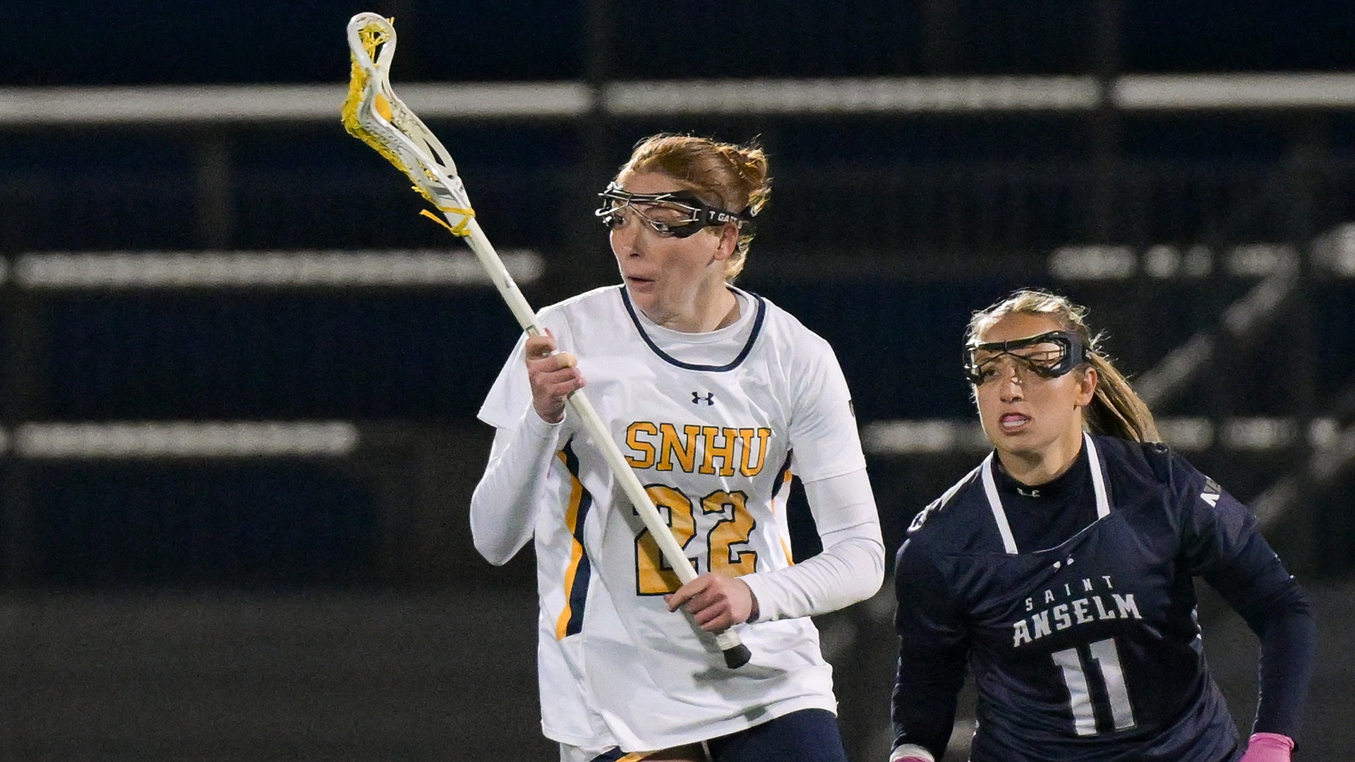 Mazie Burt with the ball in her stick and a defender in the background
