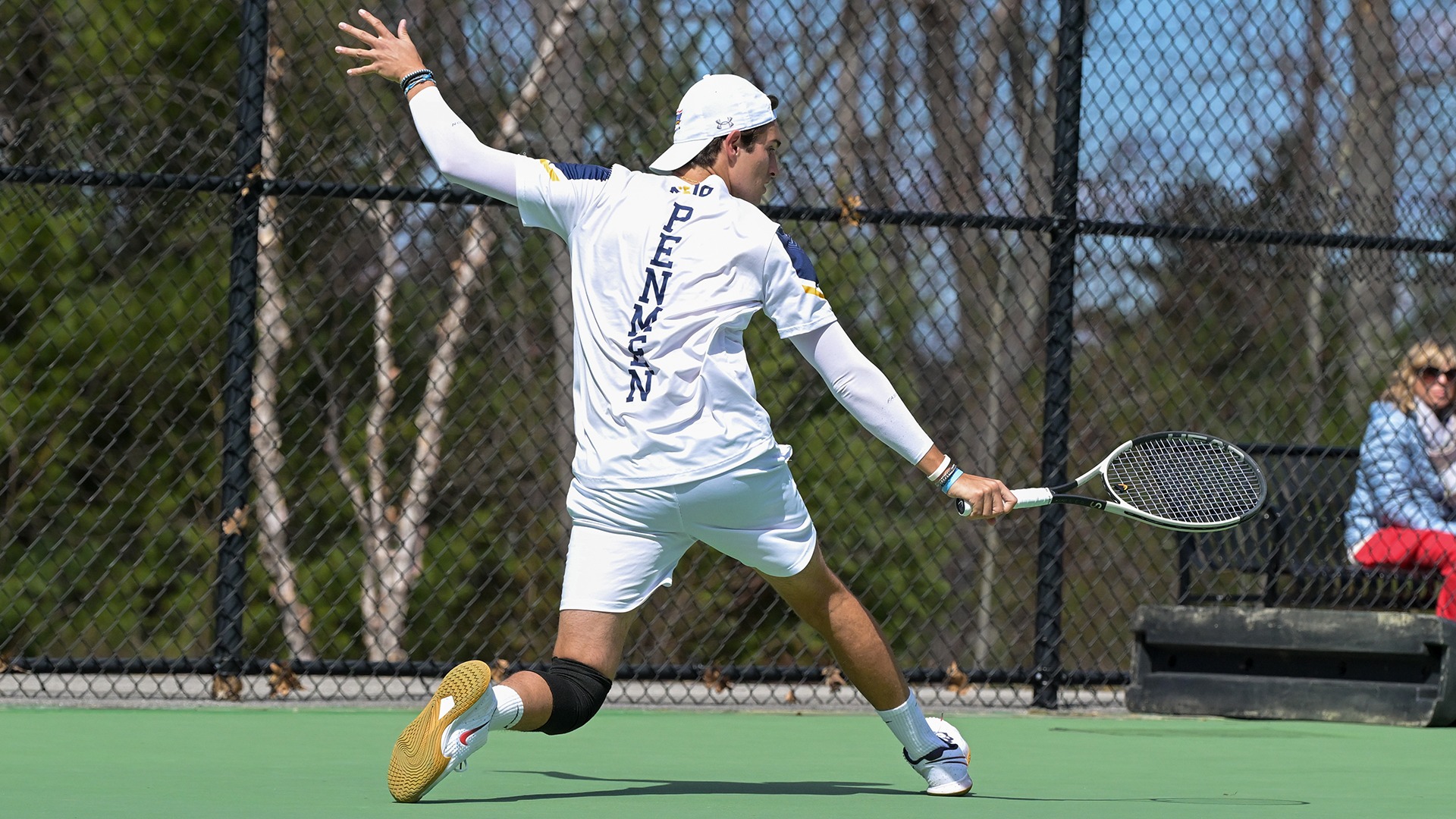 Carlos Molero hitting an acrobatic backhand shot with 