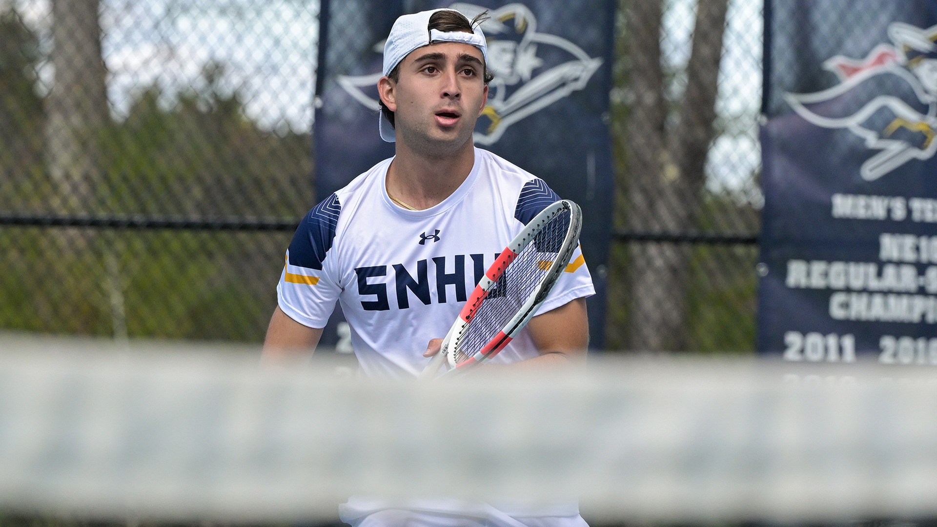 Vicente Preto holding his racquet with the net in the foreground