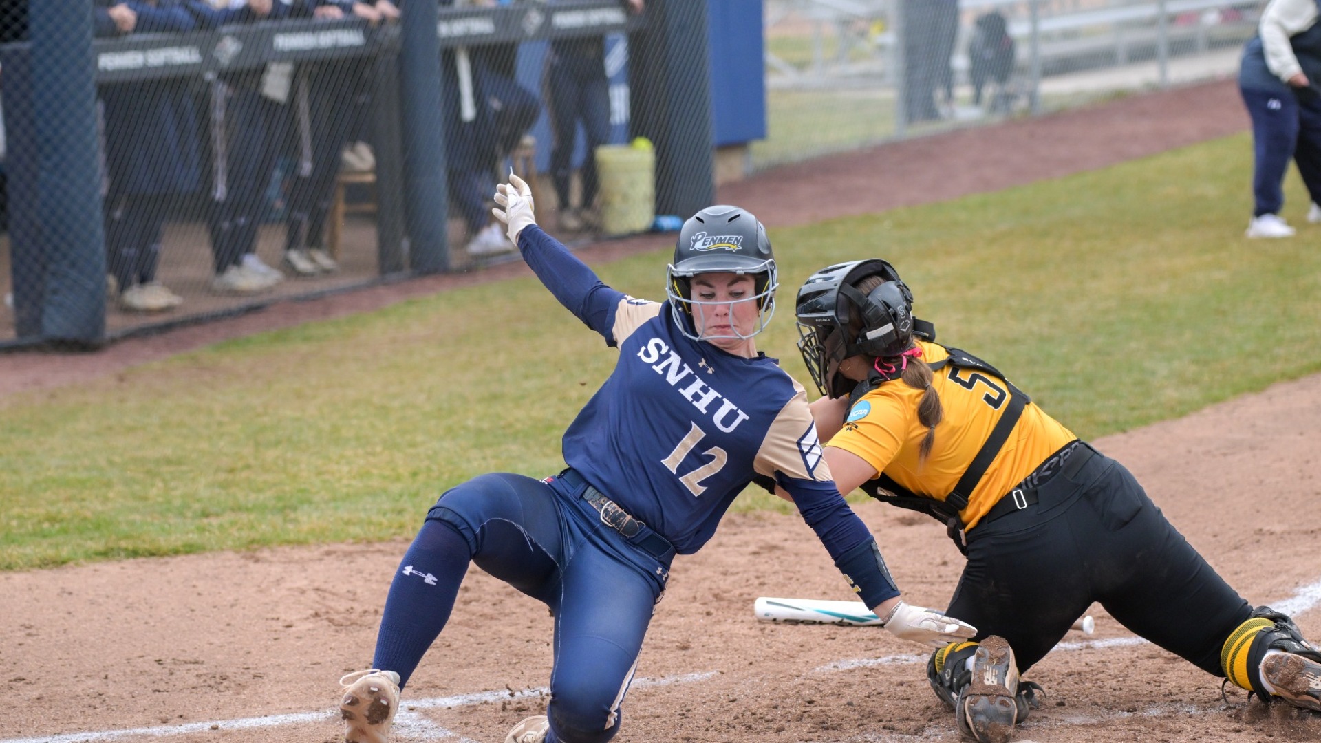 Kaysie DeMoura slides into home plate for a run for softball