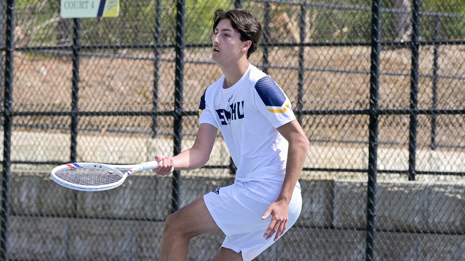 Aurel Creveuil sliding as he hits a forehand shot
