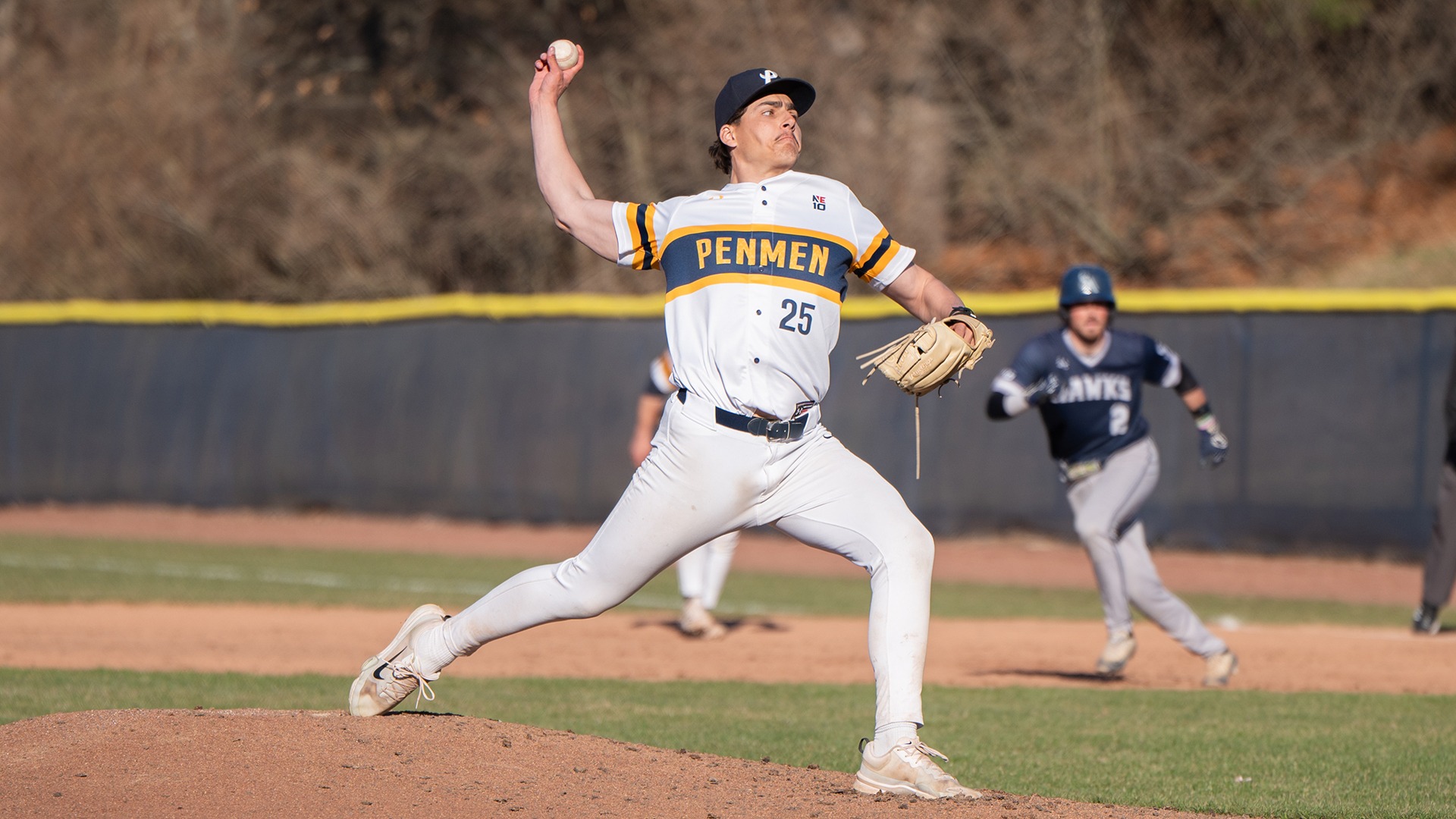 Jack Davis delivering a pitch with a Saint Anselm baserunner in the background