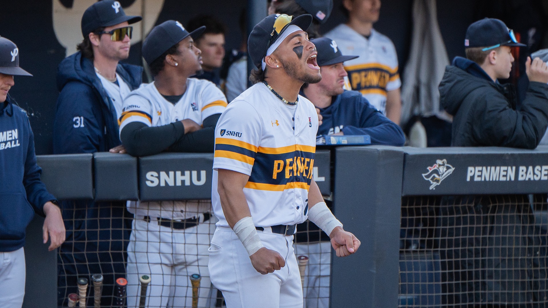 Christian Cepin yelling in celebration with his teammates in the dugout in the background