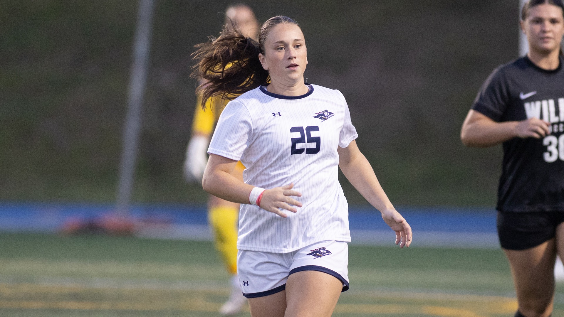 Mollie Cahalane running down the field with opponents in the background