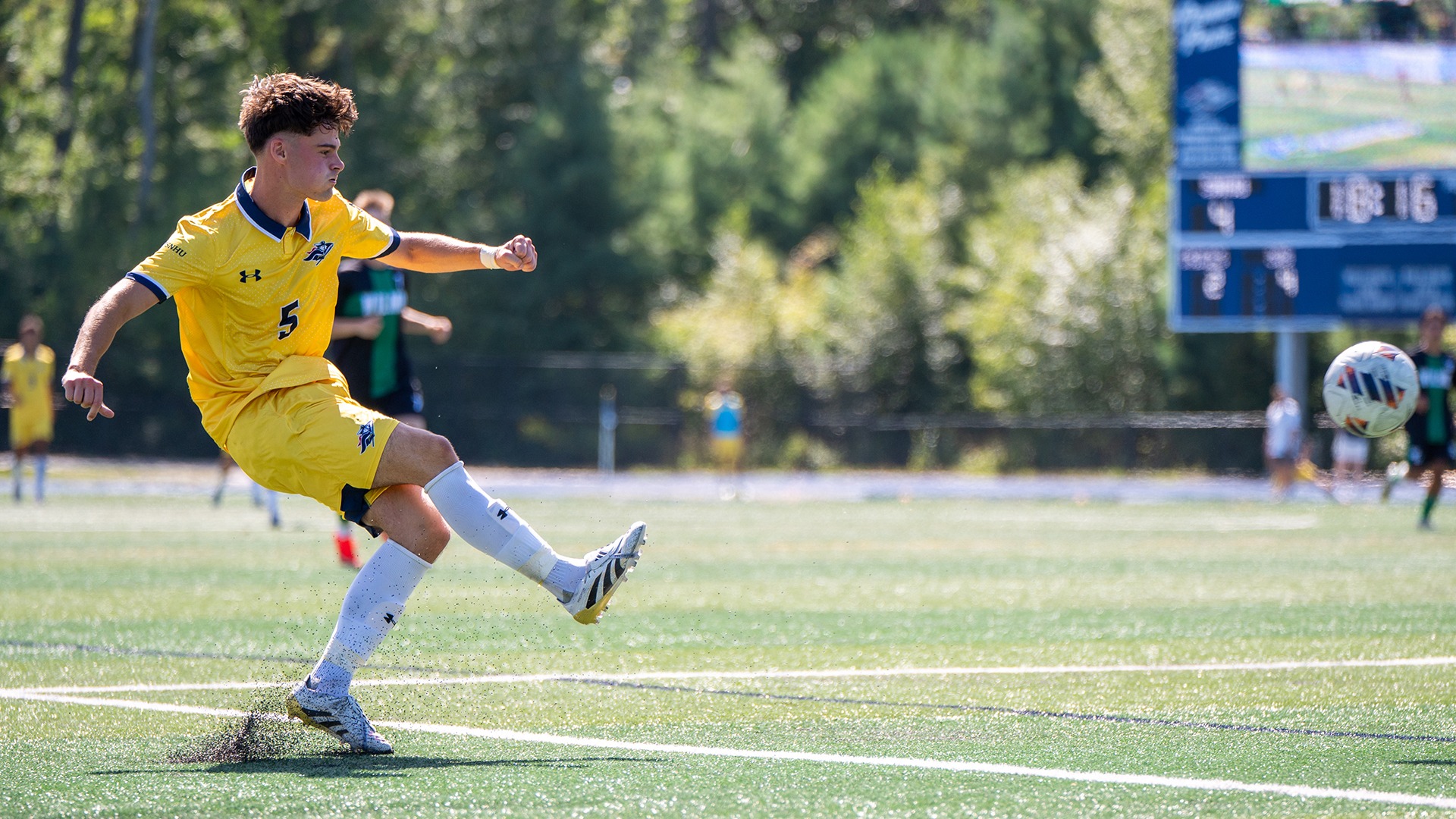 Gabriel Castro kicking the ball with teammates and opponents in the background