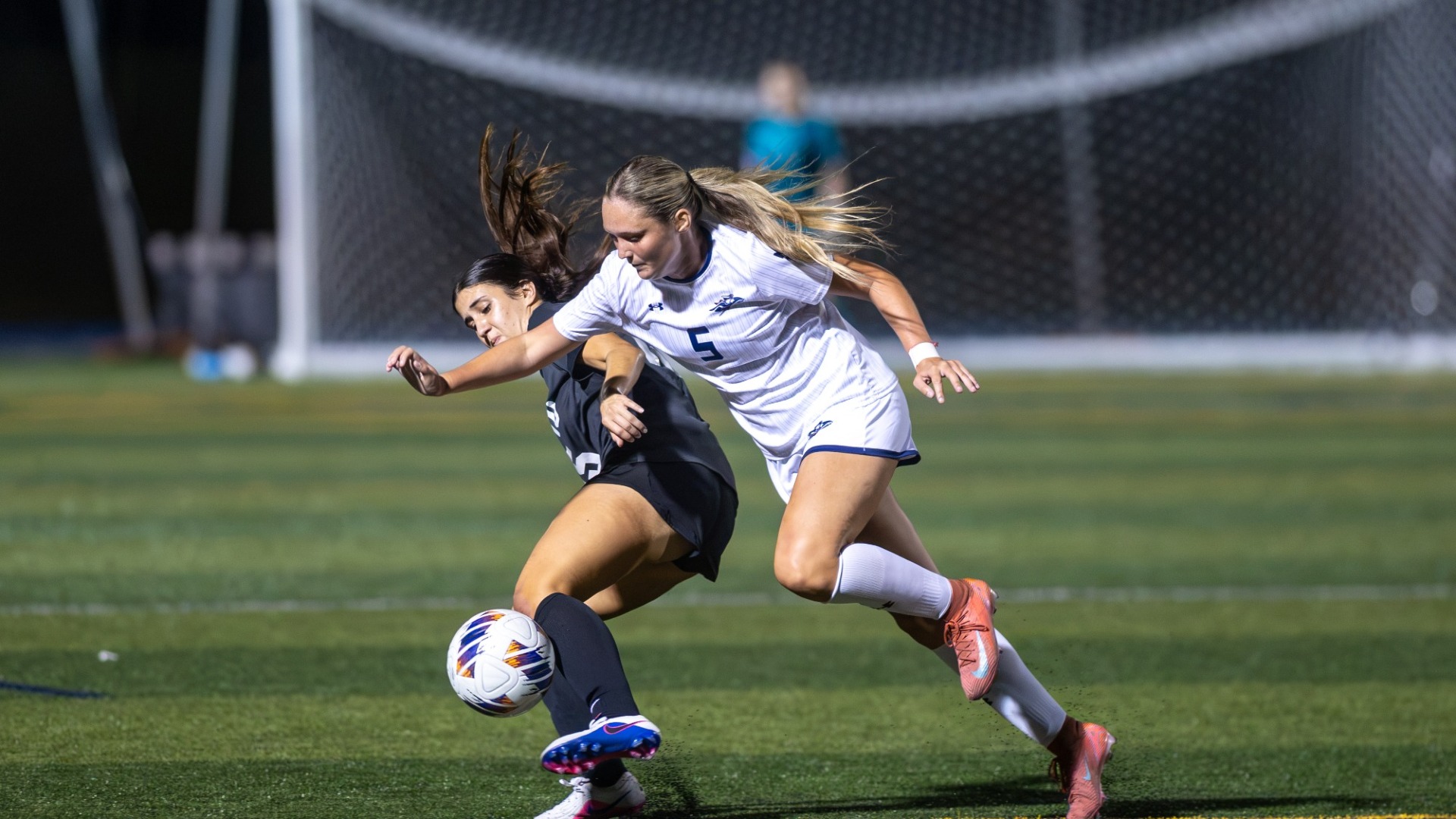 Jillian Collins battles a defender for women's soccer