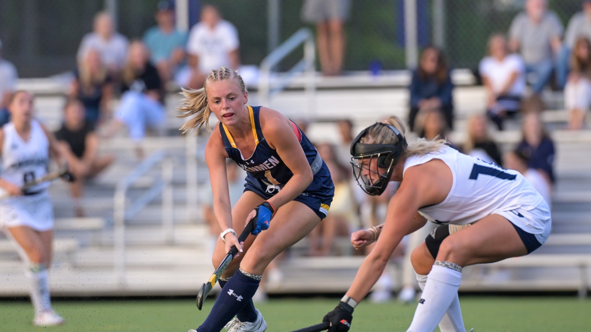 Field Hockey player Amelia Crocombe is seen in an action shot against a Saint Anselm defender