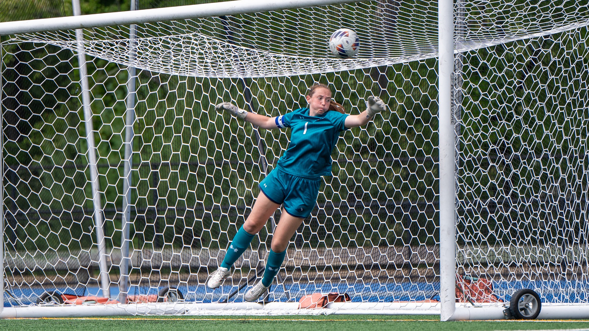 Isabel Hughes diving to make a save in front of the goal