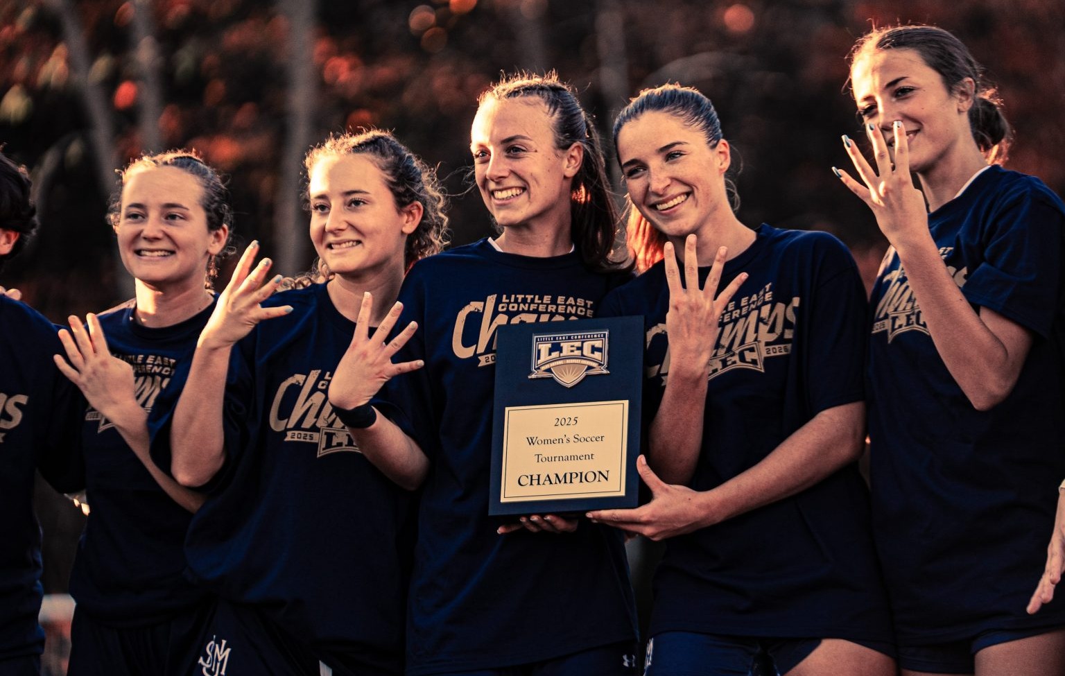 Bridgette Toland and women's soccer seniors with LEC trophy