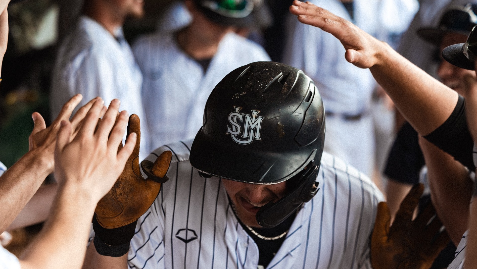 Husky Baseball Players Congratulate Teammate in Dugout