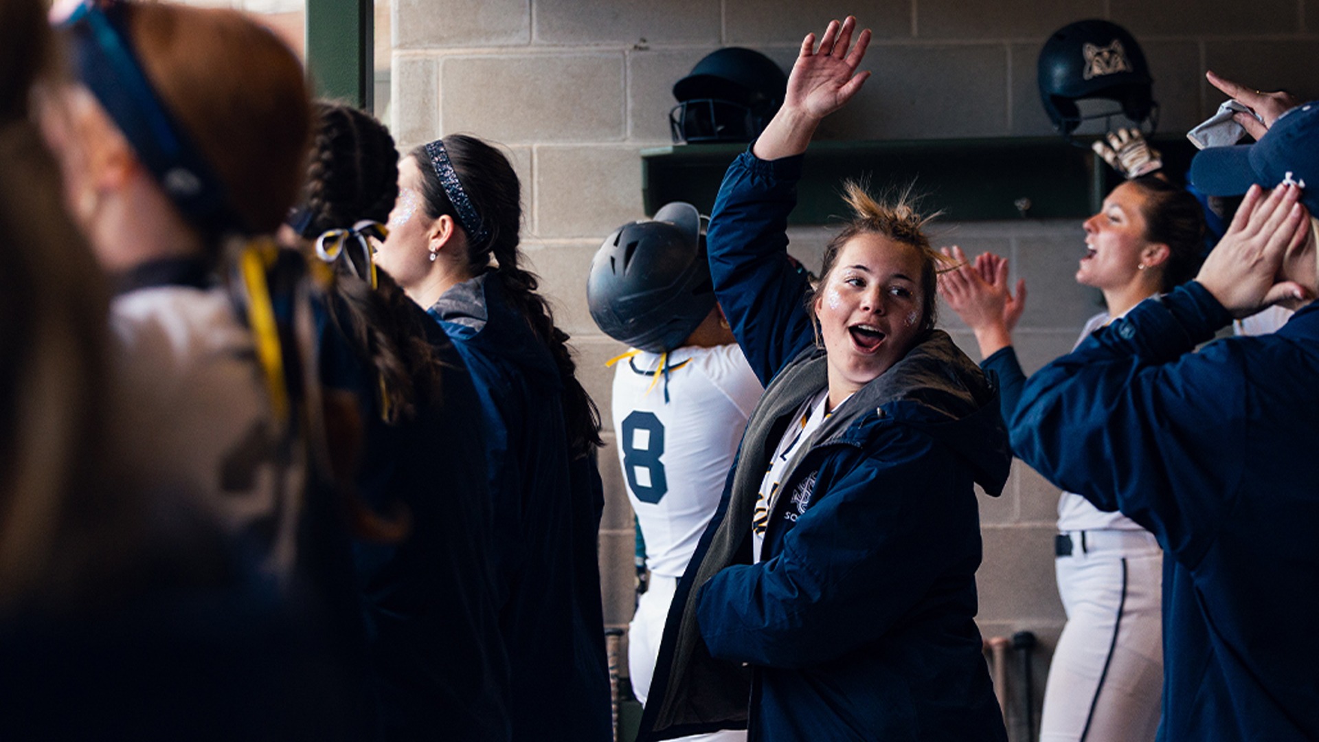 Softball Team Celebrates a Run in the Dugout