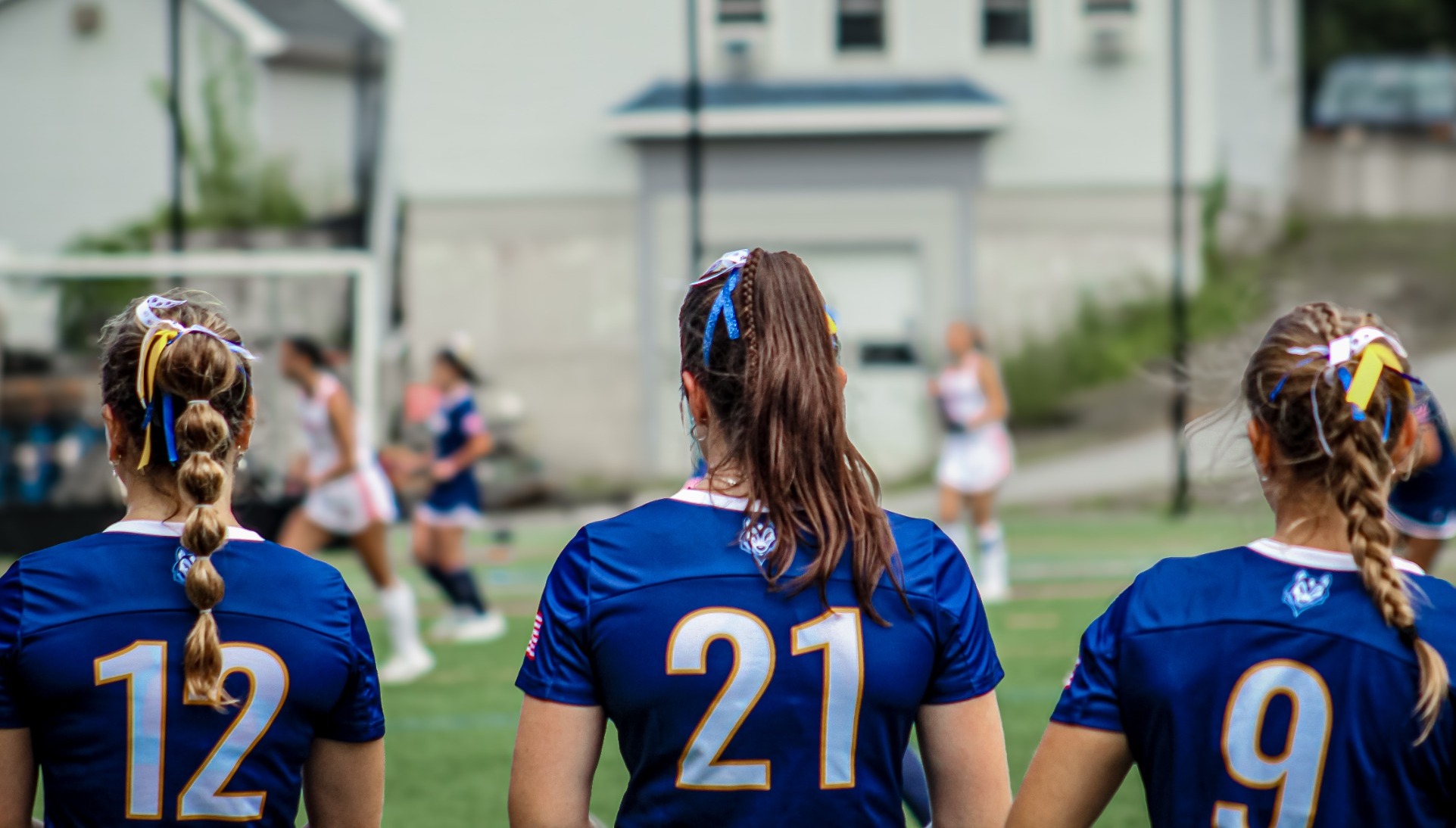 USM field hockey players on sideline watching game