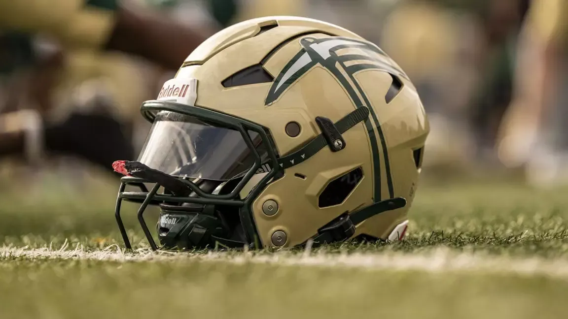 Photo of an S&T Miners Football helmet with a visor sitting on the turf at Allgood-Bailey Stadium