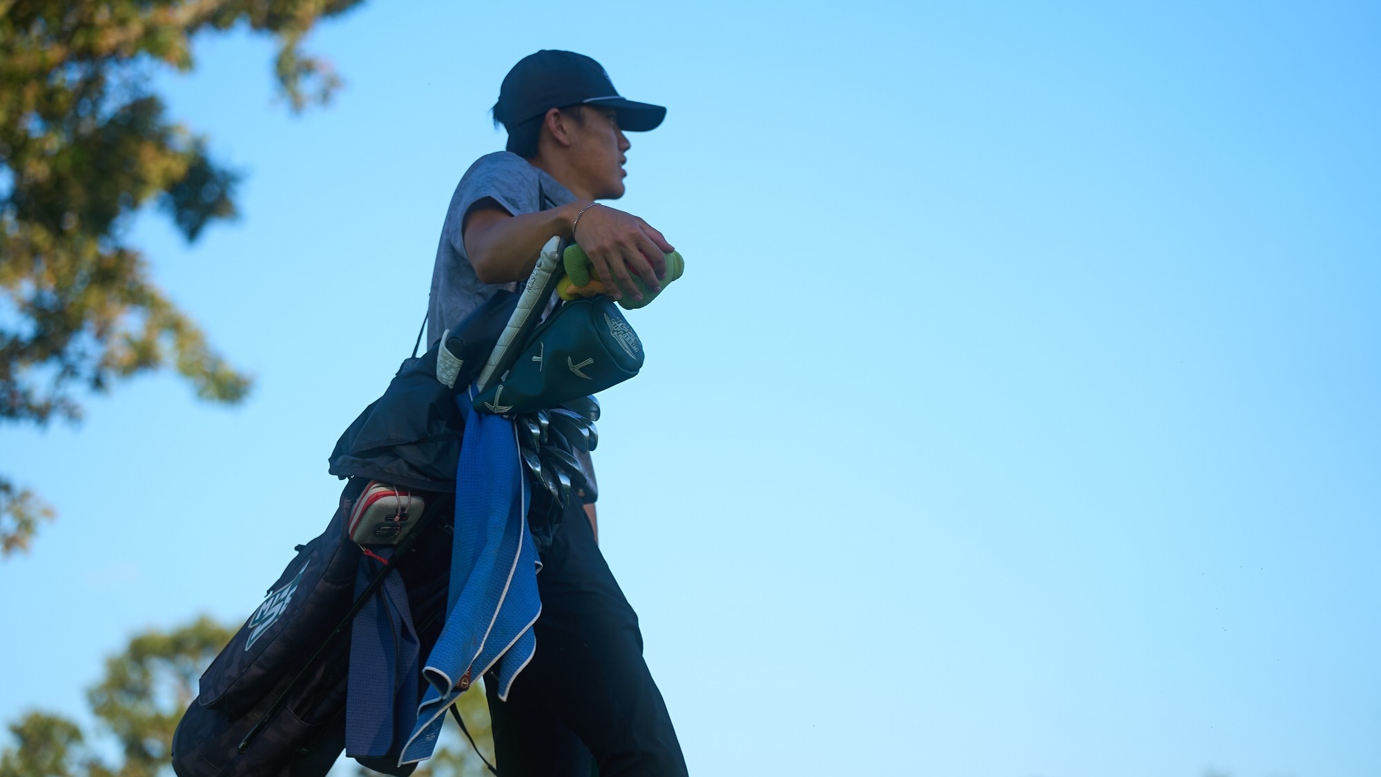 Andy Su walking while carrying his golf bag