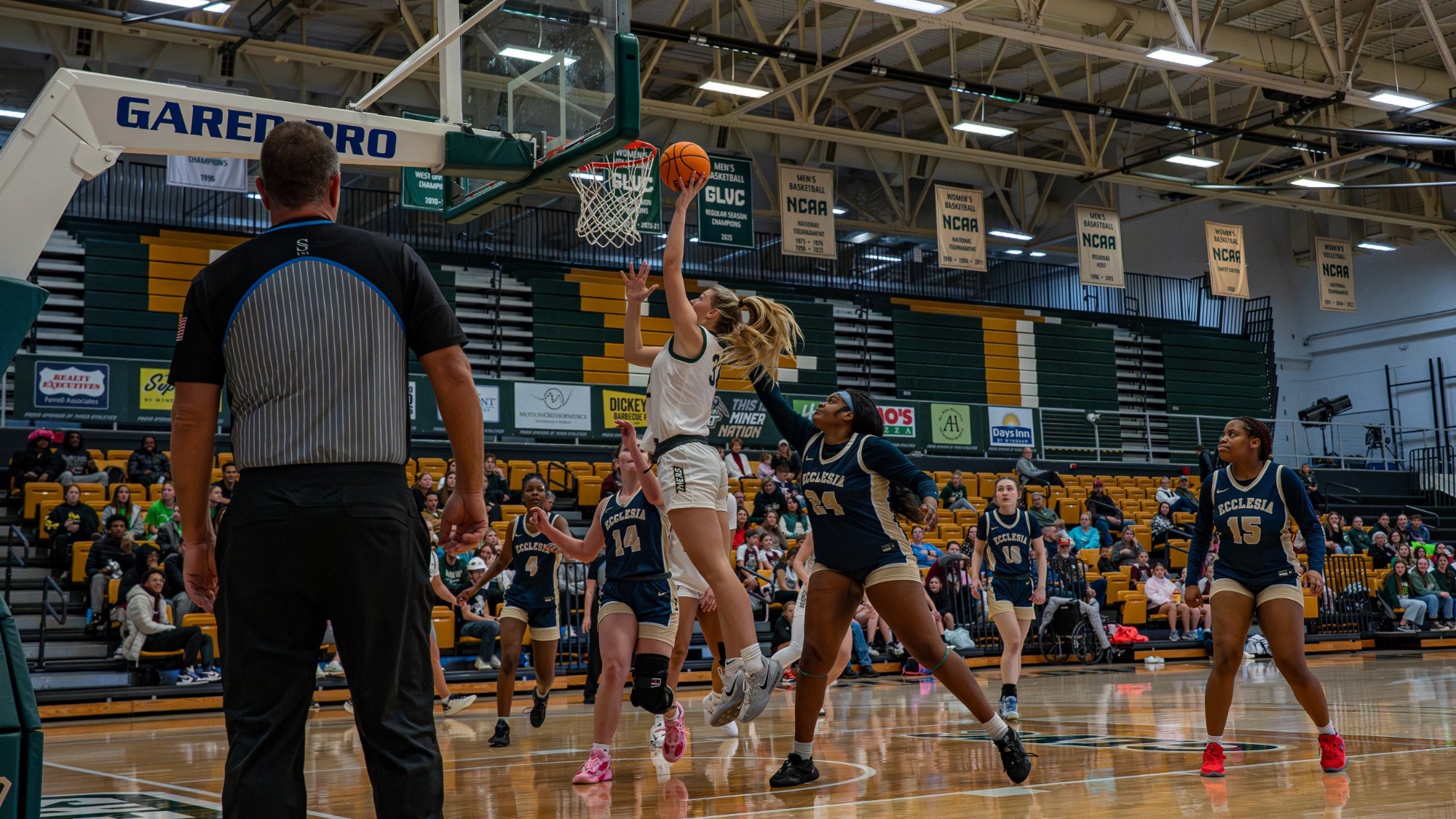 Ava McCulla going up for a layup surrounded by Ecclesia defenders
