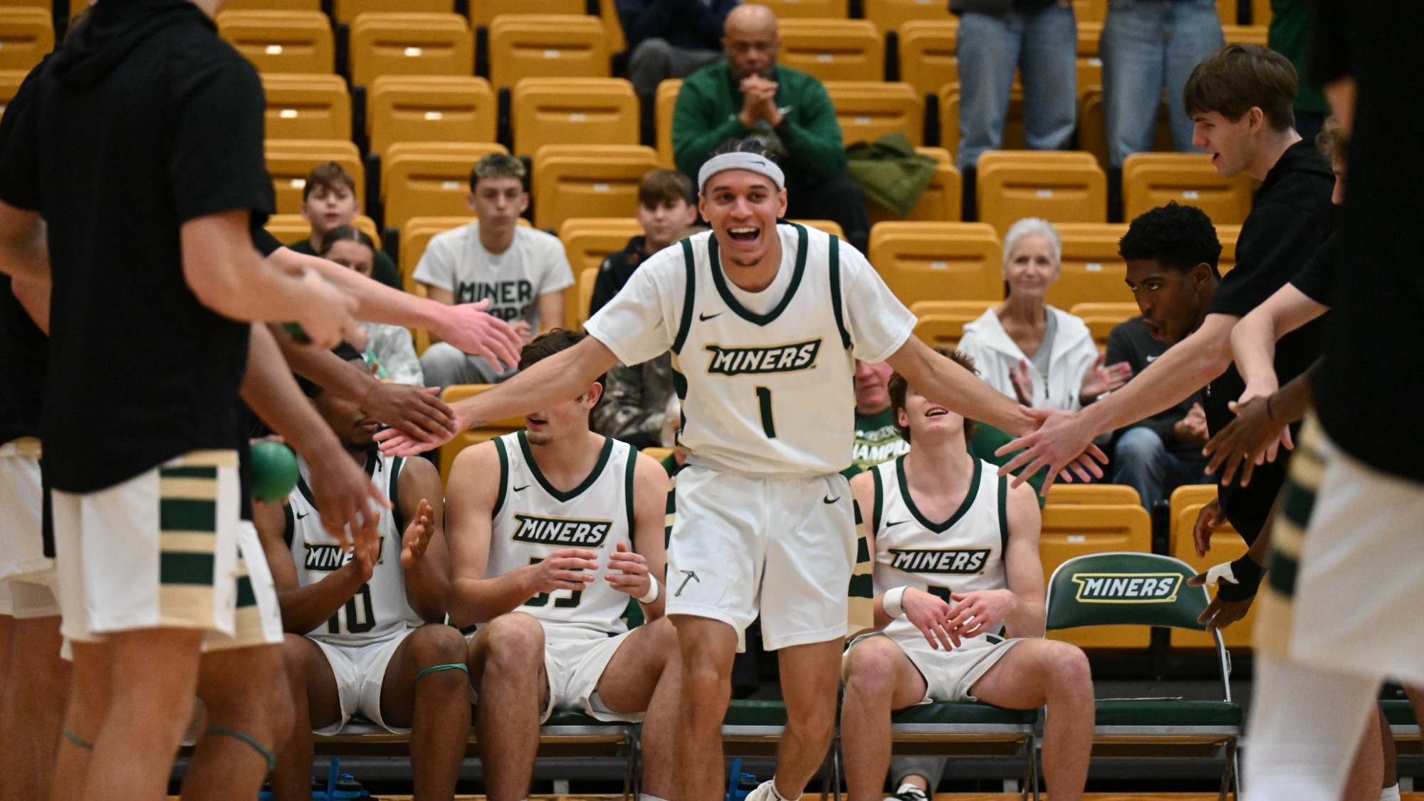 Blaise Beauchamp high-fiving teammates during basketball starting lineups in Gibson Arena