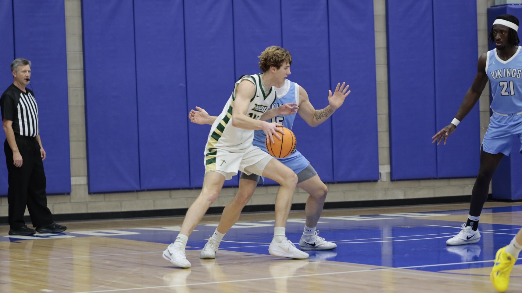 Photo of Missouri S&T basketball player Andrew Young leaning into a WWU defender as he dribbles into the paint