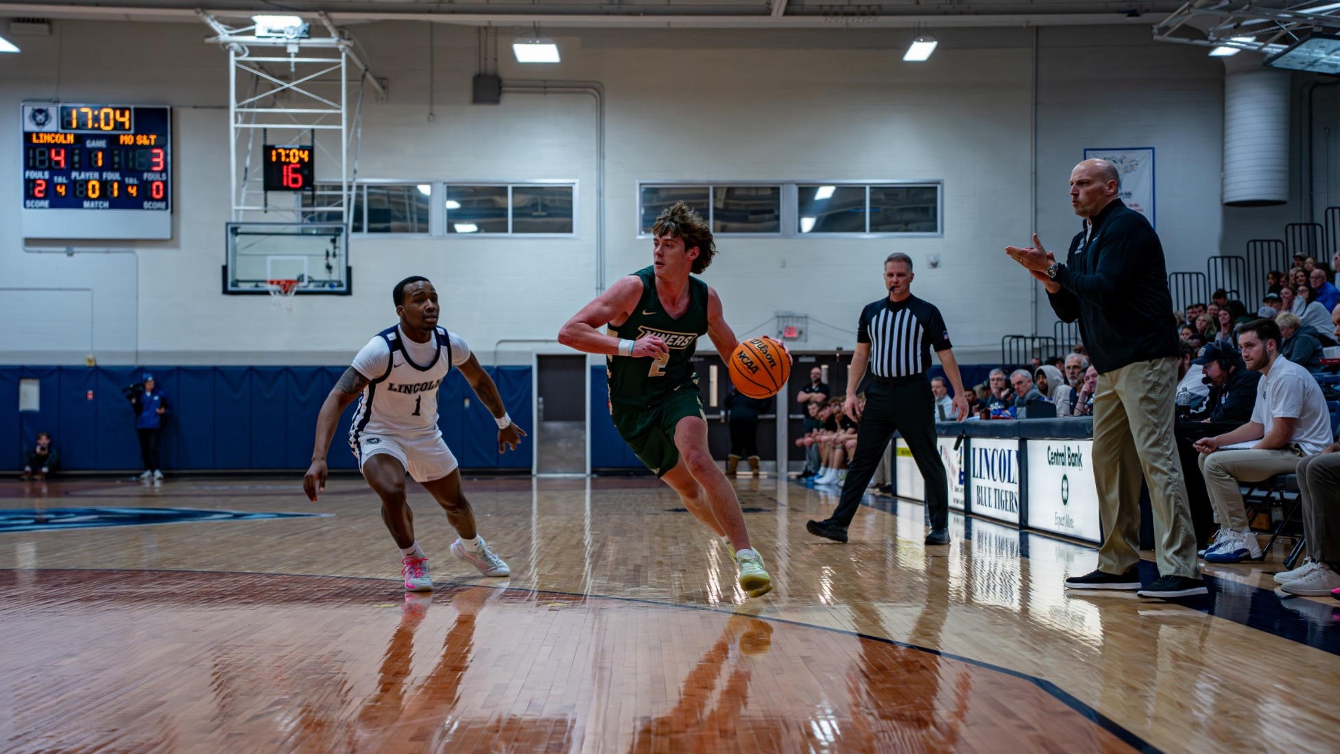 a photo of missouri S&T men's basketball player Alex Benassi dribbling the basketball with his left hand and driving towards the hoop while at Lincoln of Missouri