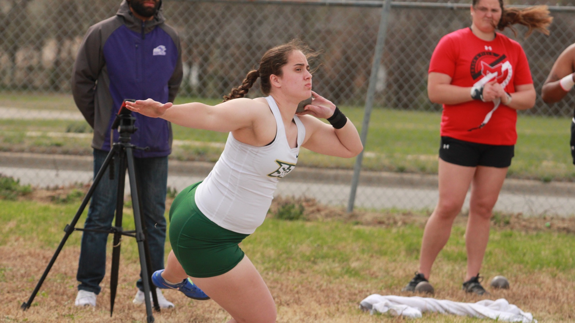 Sydney Morris throwing a shot put during a track meet.