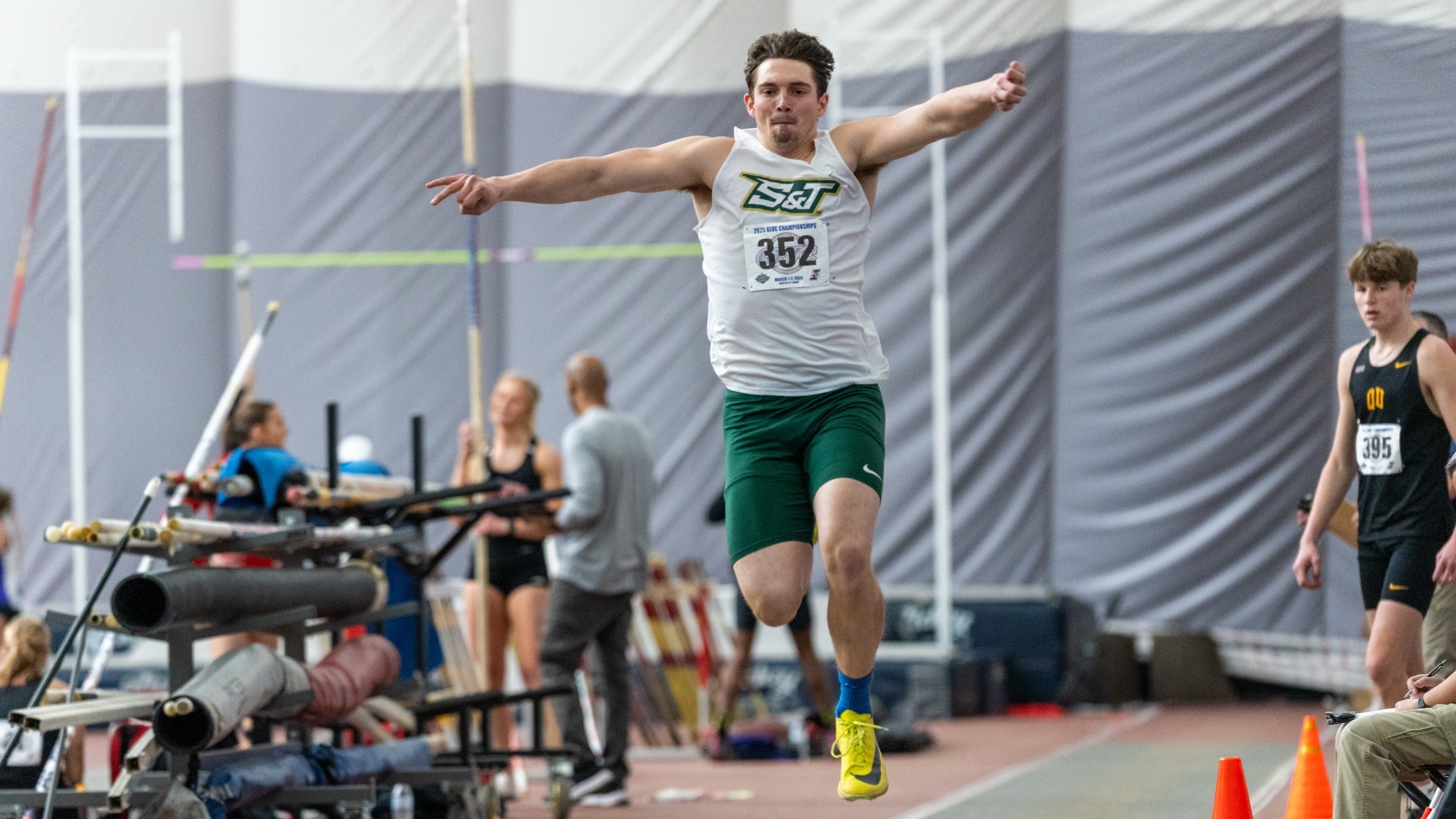 Action shot of Justin Chadwell mid jump competing in long jump.