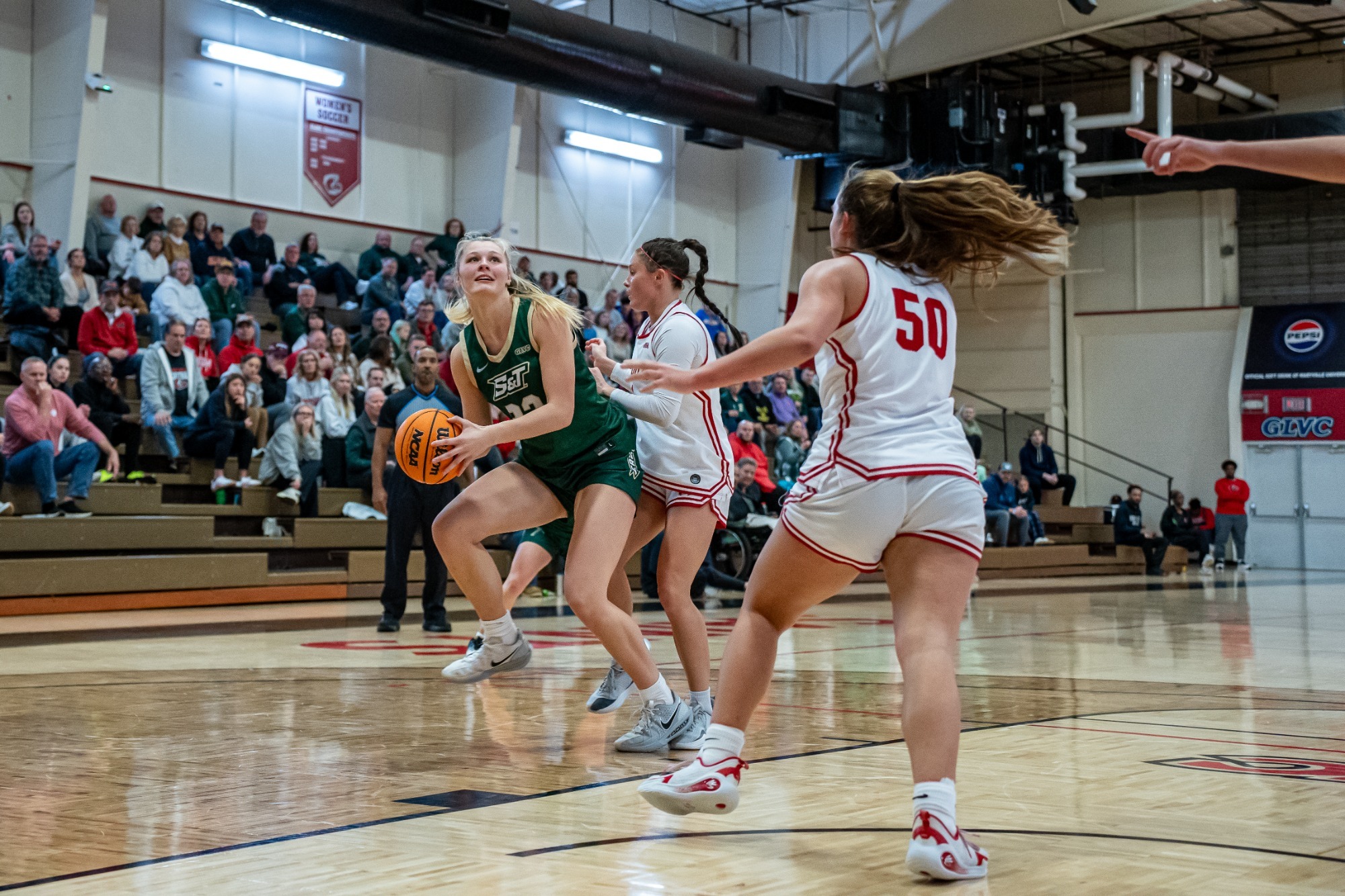 Ava McCulla getting ready to make a post move against two Maryville defenders at Maryville University.
