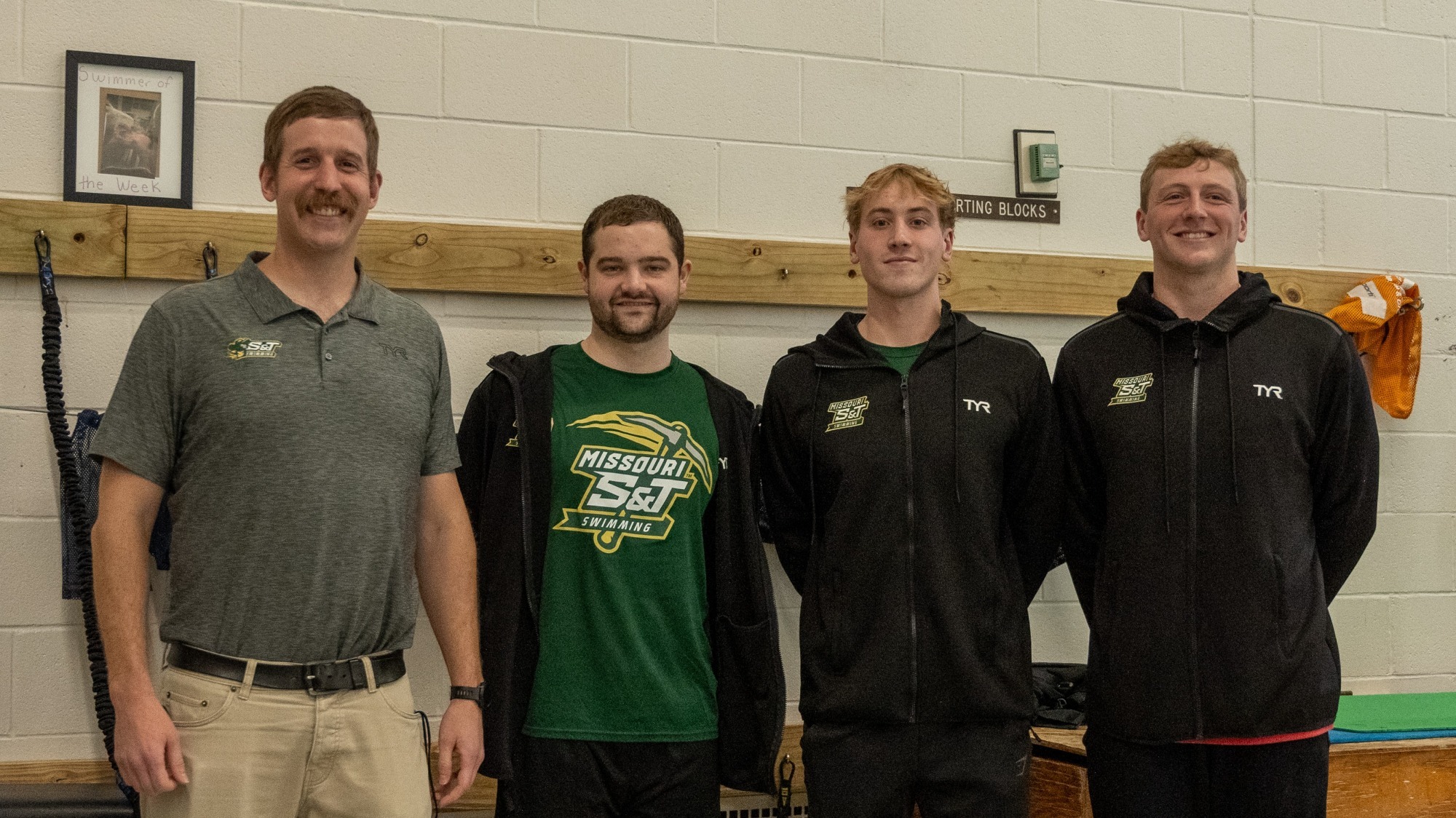 photo of head swim coach Danny Murphy standing to the right of Cameron McCrary standing to the right of Connor Bichsel standing to the right of Jordan Christensen during senior day at an S&T swim meet