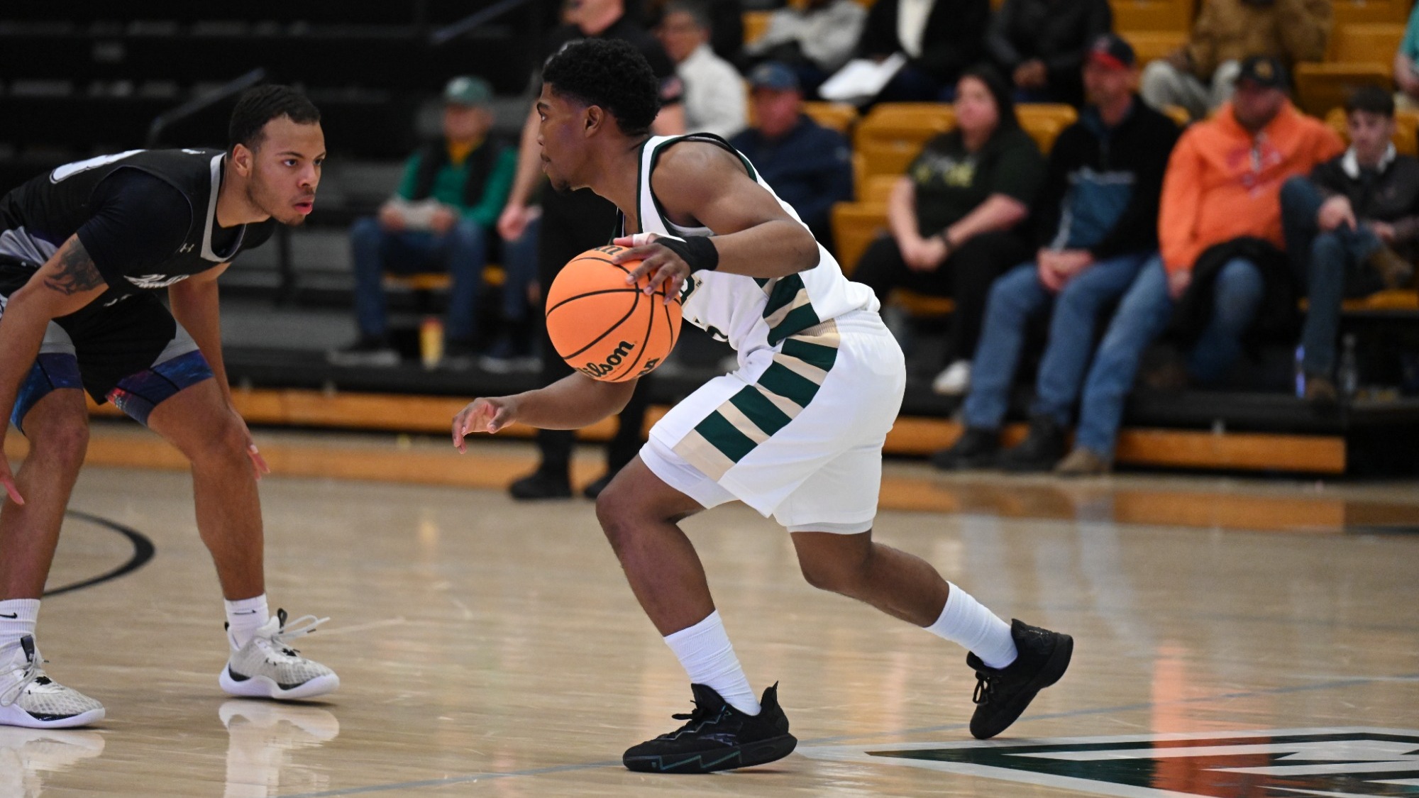 Missouri S&T men's basketball player Darron Henry dribbles the basketball at the top of the key as a Truman Defender stands in his path