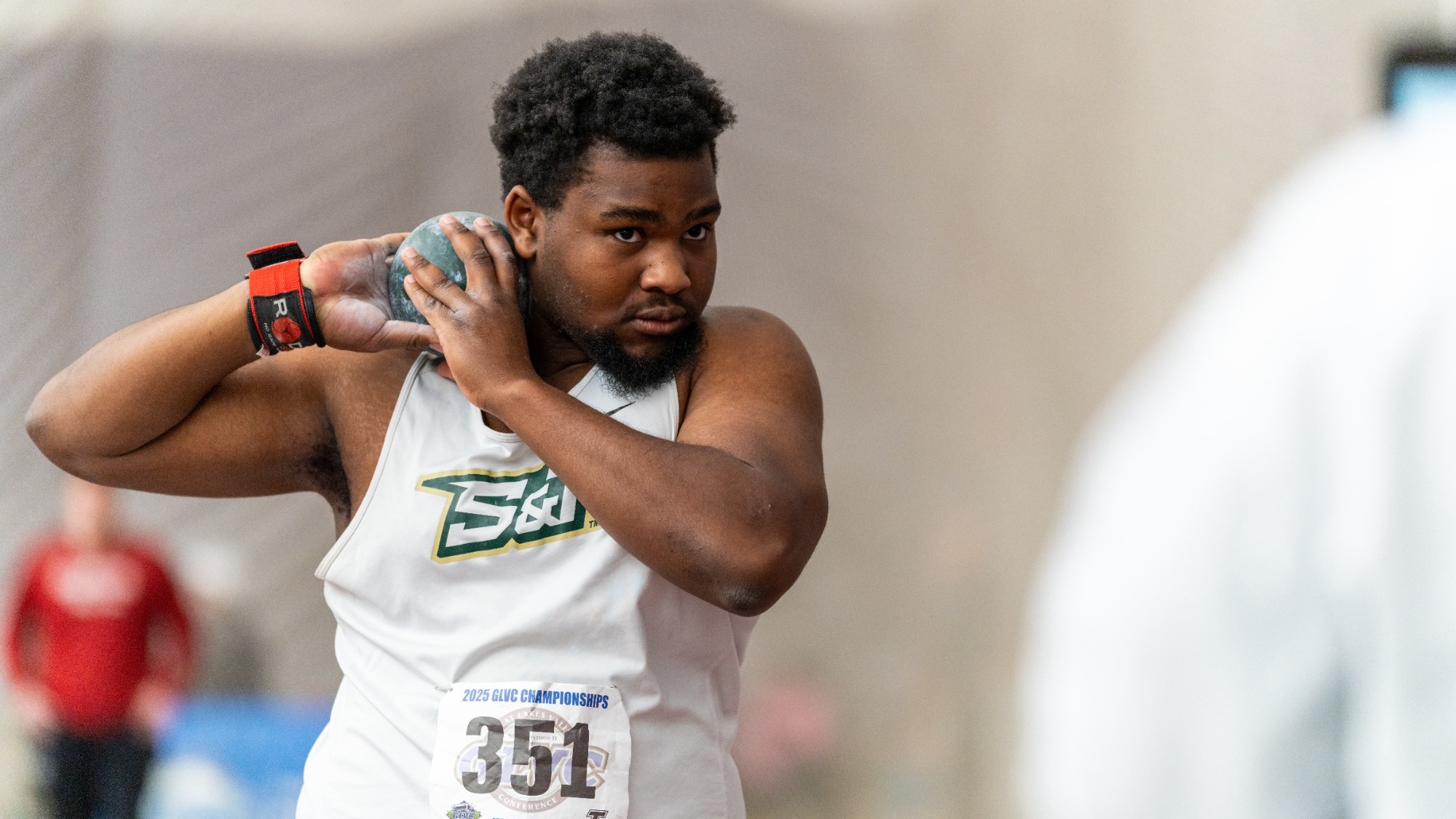 DJ Carter of Missouri S&T Track & Field positioning shot put on shoulder at meet.